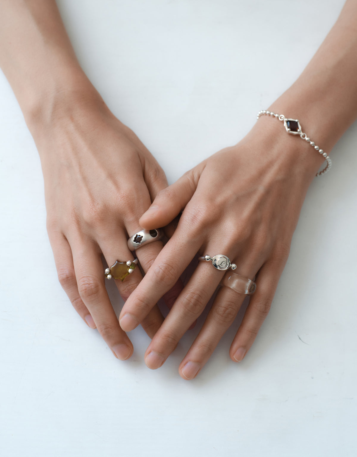 LAS Scallop Swivel Ring | Engraving worn on the model, both hands laid flat with several sterling silver rings and a bracelet. Handmade in Los Angeles. LAS Scallop Swivel Ring | Engraving by CLED.