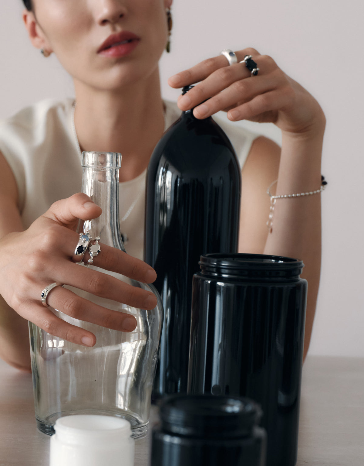 Eyelet Scallop Ring worn on the model among discarded glass bottles, the source of every CLED Eco Gem. Handmade in Los Angeles. Eyelet Scallop Ring by CLED.