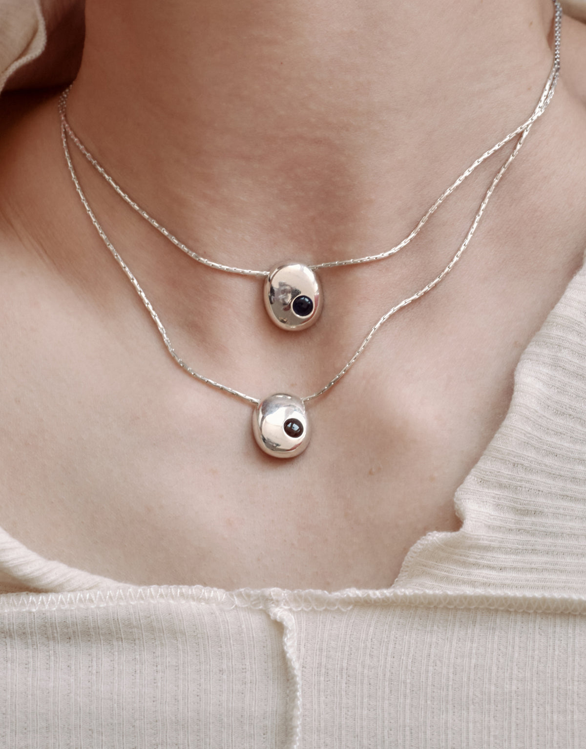 Inter Loop Necklace worn on the model, upcycled glass Eco Gem set in sterling silver. Handmade in Los Angeles. Inter Loop Necklace by CLED.