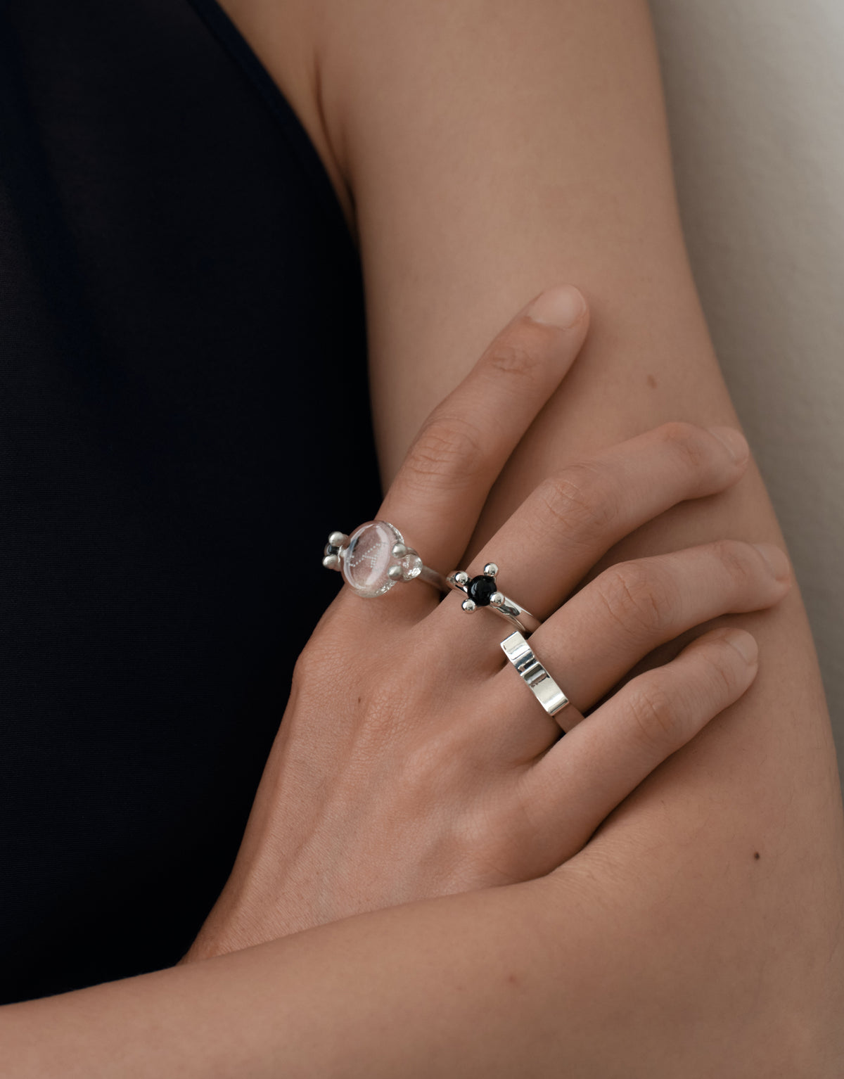 LAS Oval Swivel Ring | Engraving worn on the model, an arm drawn across the body with stacked sterling silver rings. Handmade in Los Angeles. LAS Oval Swivel Ring | Engraving by CLED.
