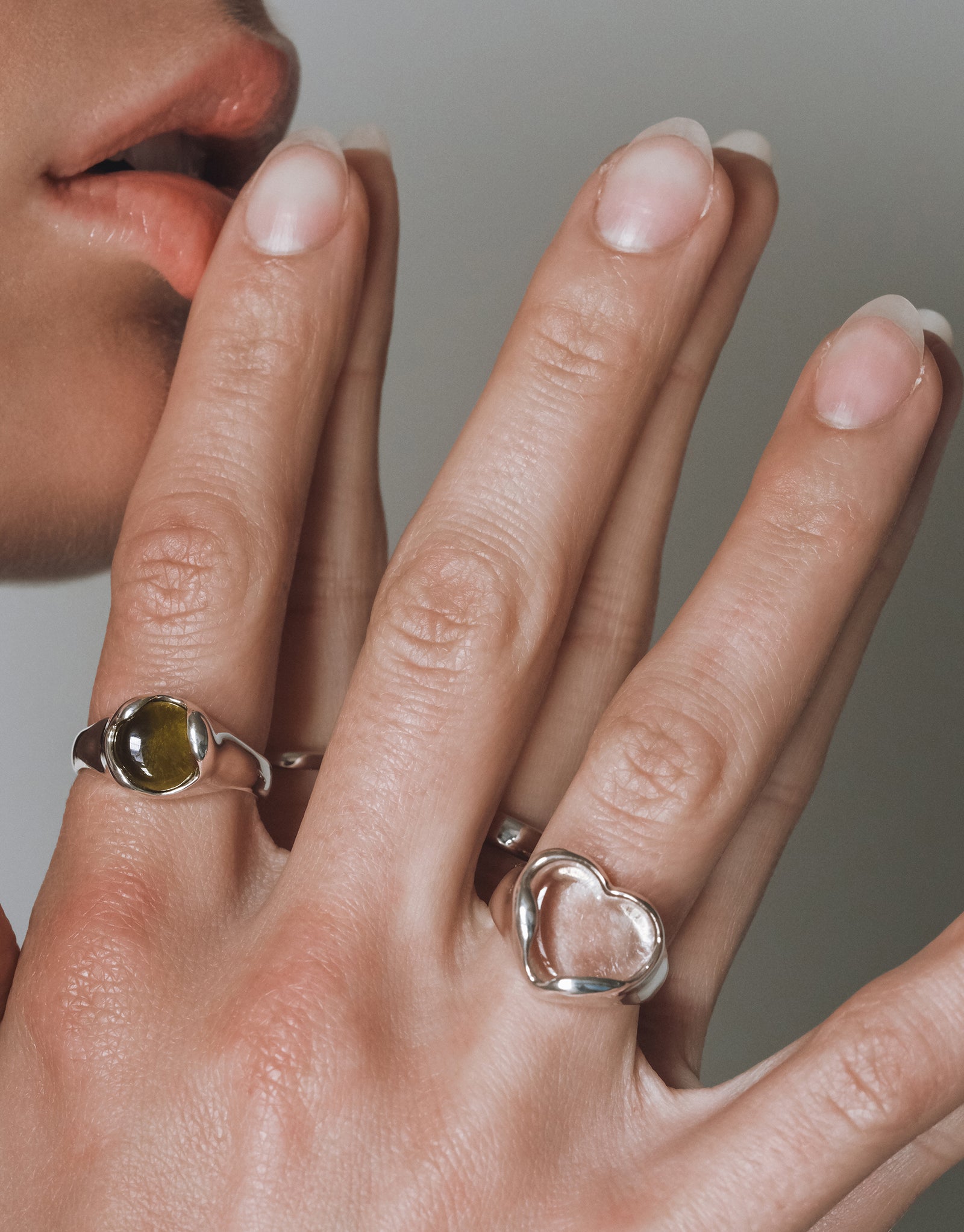 Silver Orb Ring with green eco gem center in elegant curved setting shown on hand with natural manicure - CLED