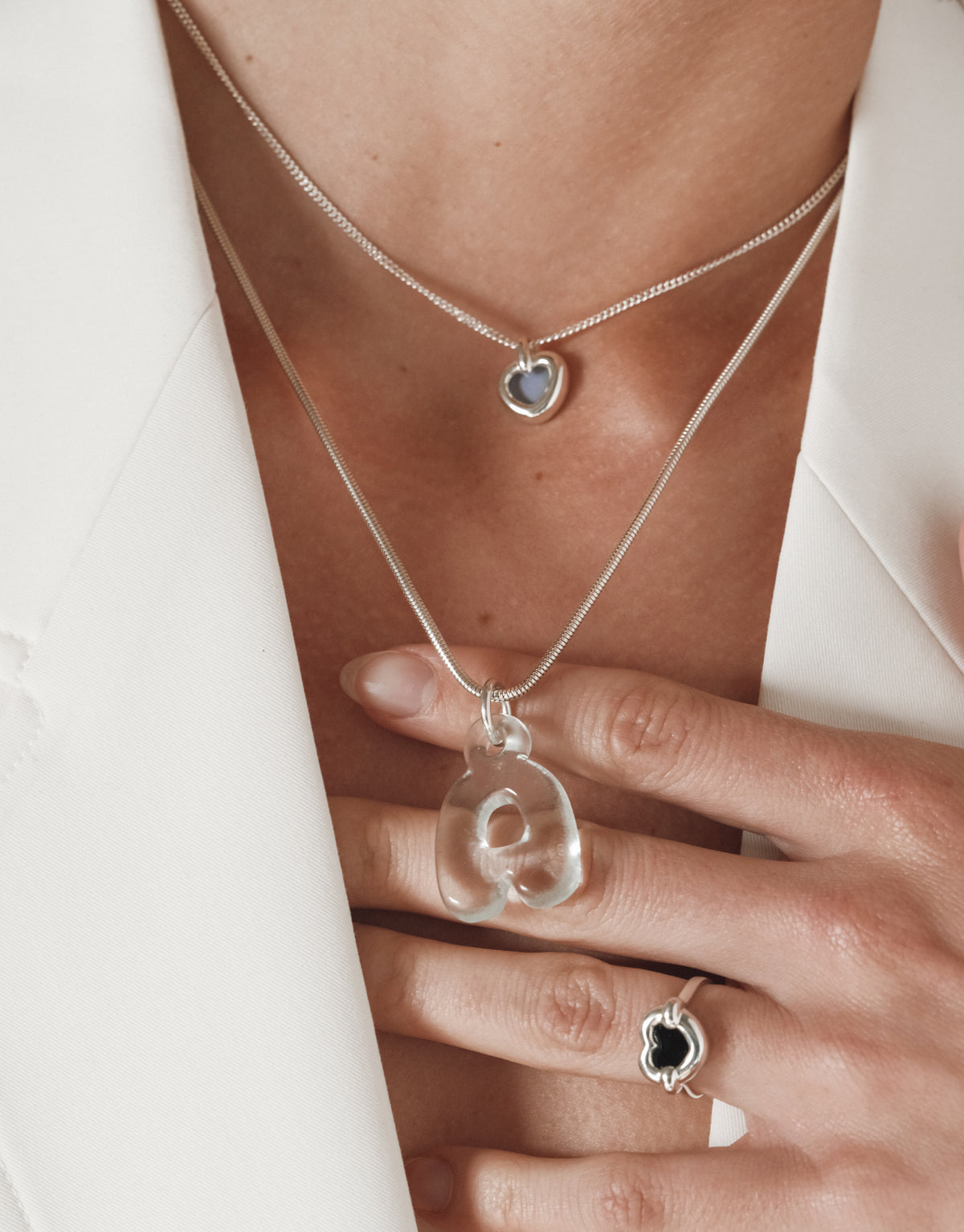 Core Heart Necklace | Small: A person wears a lightweight, heart-shaped pendant, showcasing its seamless, fluid design. The necklace embodies CLED's eco-conscious ethos, crafted from repurposed materials.