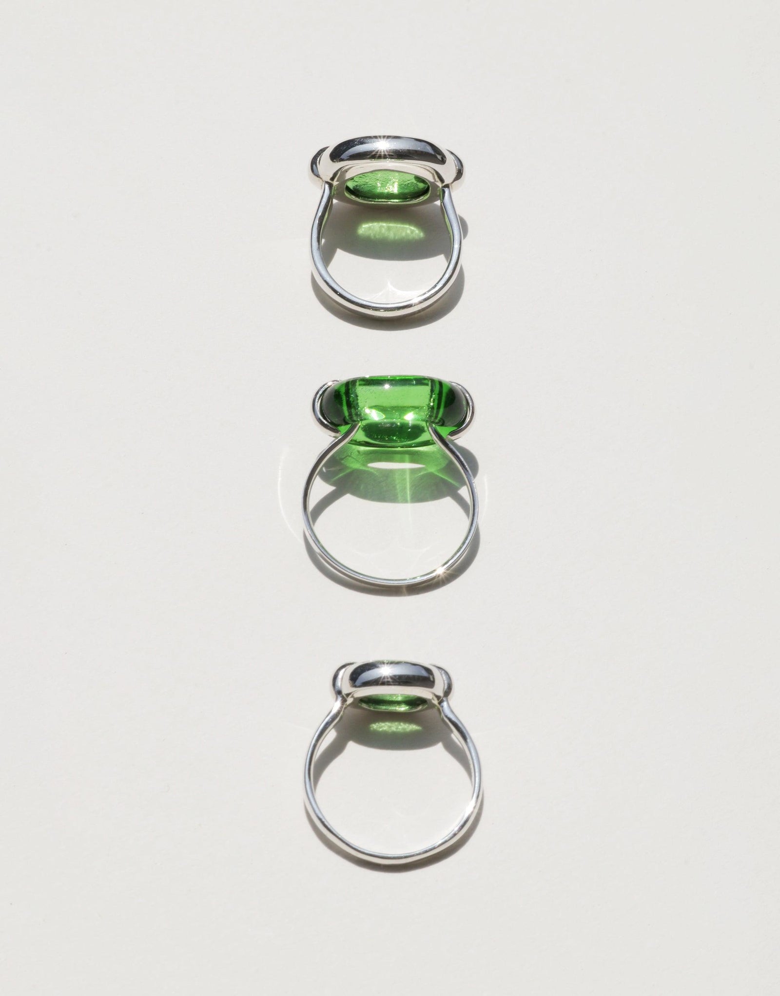 Three silver rings with green glass elements, showcasing the Core Loop Ring | Small design. Unique upcycled jewelry symbolizing unity and sustainability. Elegant and eco-friendly accessories for conscious consumers. CLED Core Loop Ring | Small.
