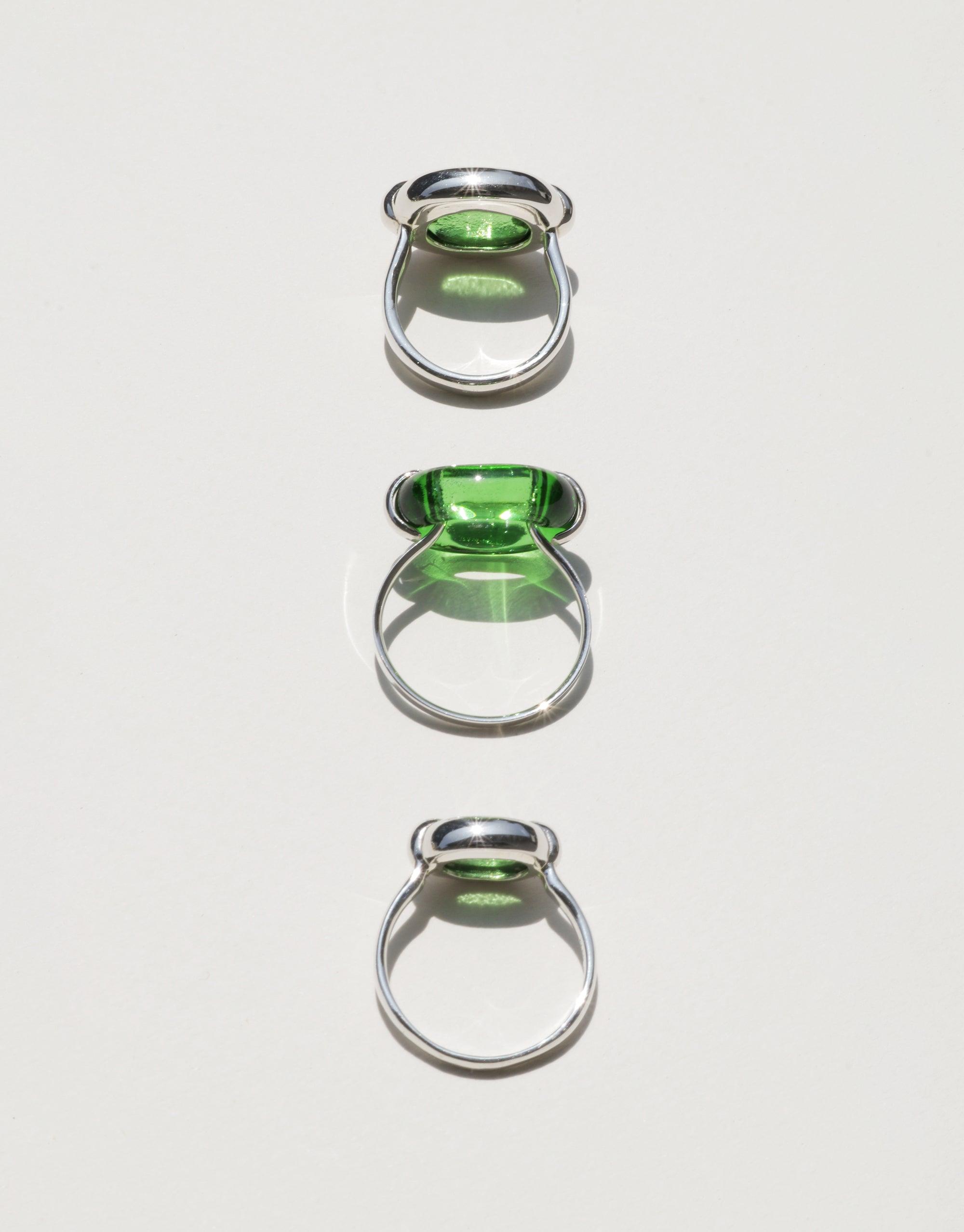 Three silver rings with green glass elements, showcasing the Core Loop Ring | Small design. Unique upcycled jewelry symbolizing unity and sustainability. Elegant and eco-friendly accessories for conscious consumers. CLED Core Loop Ring | Small.