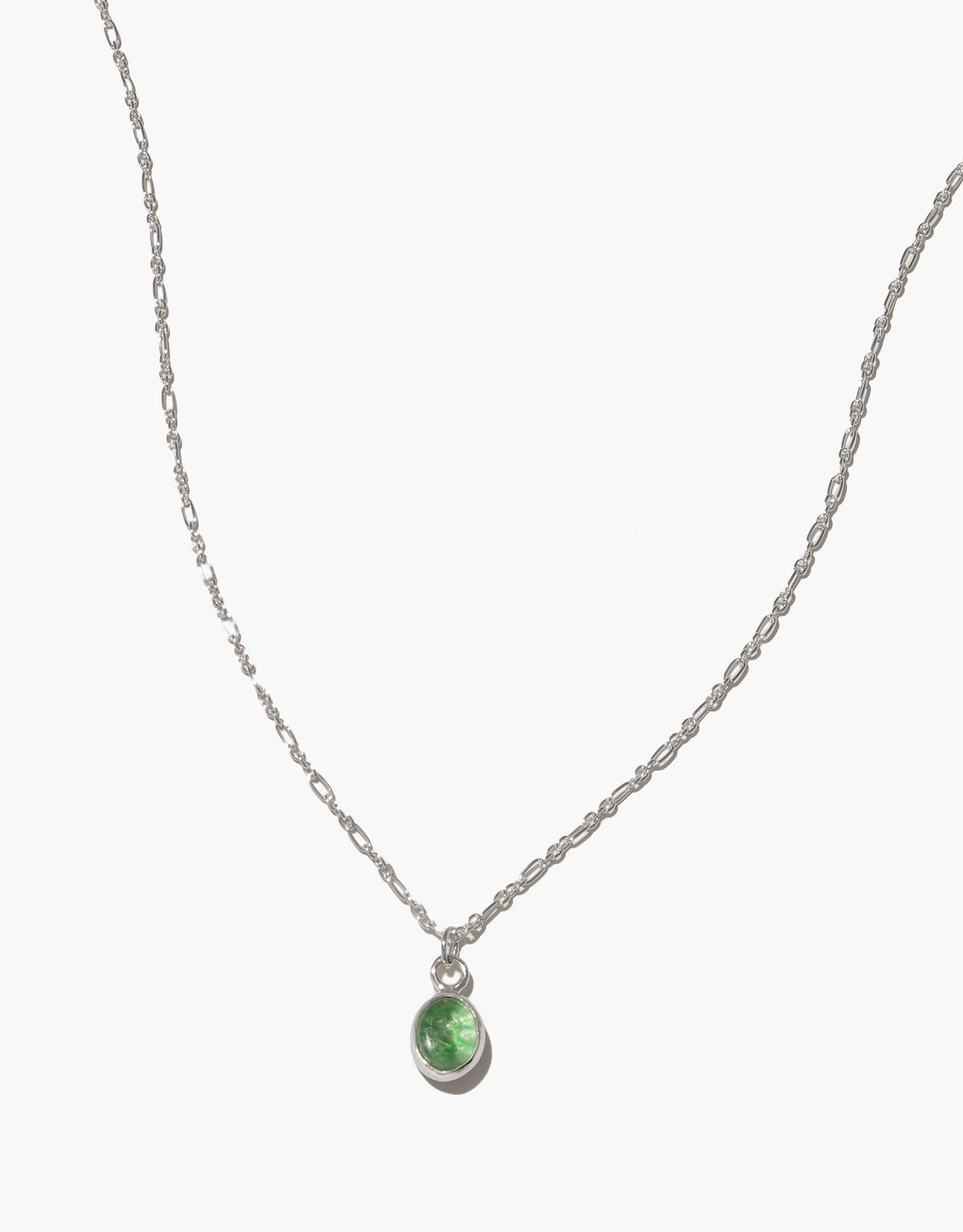 Delicate silver chain necklace with small oval green charm pendant, showcasing eco-friendly upcycled glass. Adjustable length for versatile styling. Handcrafted jewelry piece. Oval Charm Necklace by CLED.