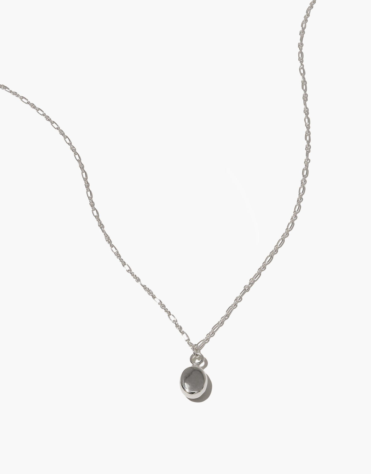 Delicate sterling silver chain necklace with a small oval charm pendant, featuring an adjustable length and handcrafted design. Oval Charm Necklace showcases eco-friendly materials and minimalist style for everyday elegance. CLED