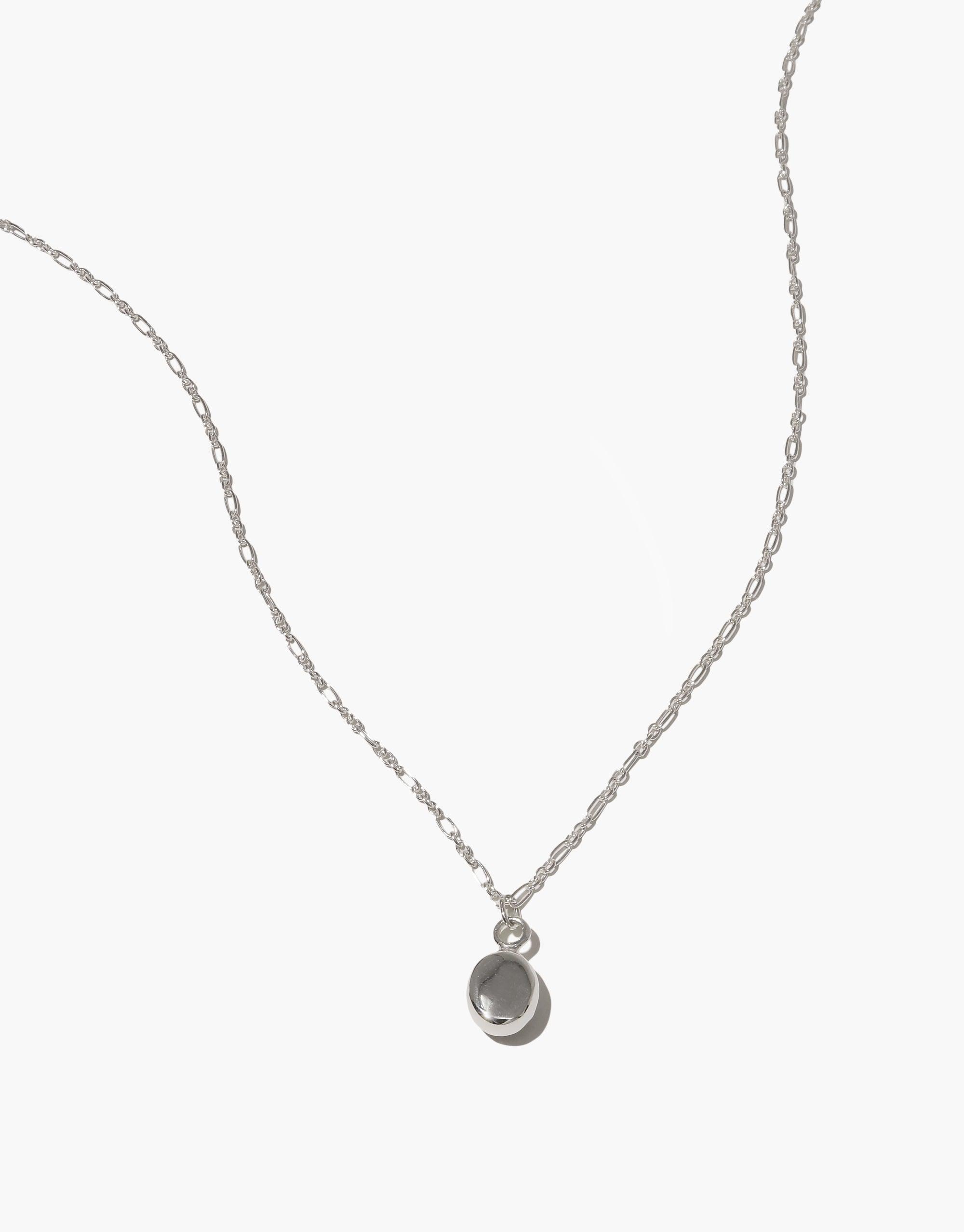 Delicate sterling silver chain necklace with a small oval charm pendant, featuring an adjustable length and handcrafted design. Oval Charm Necklace showcases eco-friendly materials and minimalist style for everyday elegance. CLED