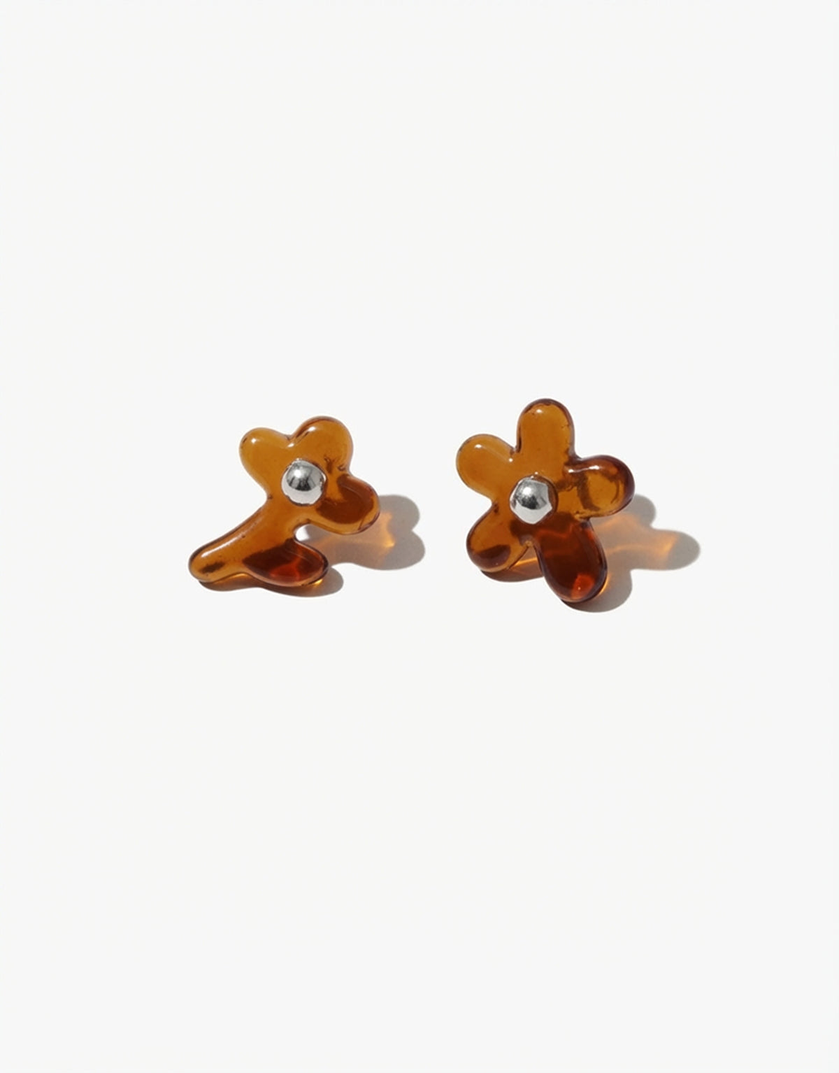 Pair of brown flower-shaped earrings on a white background
