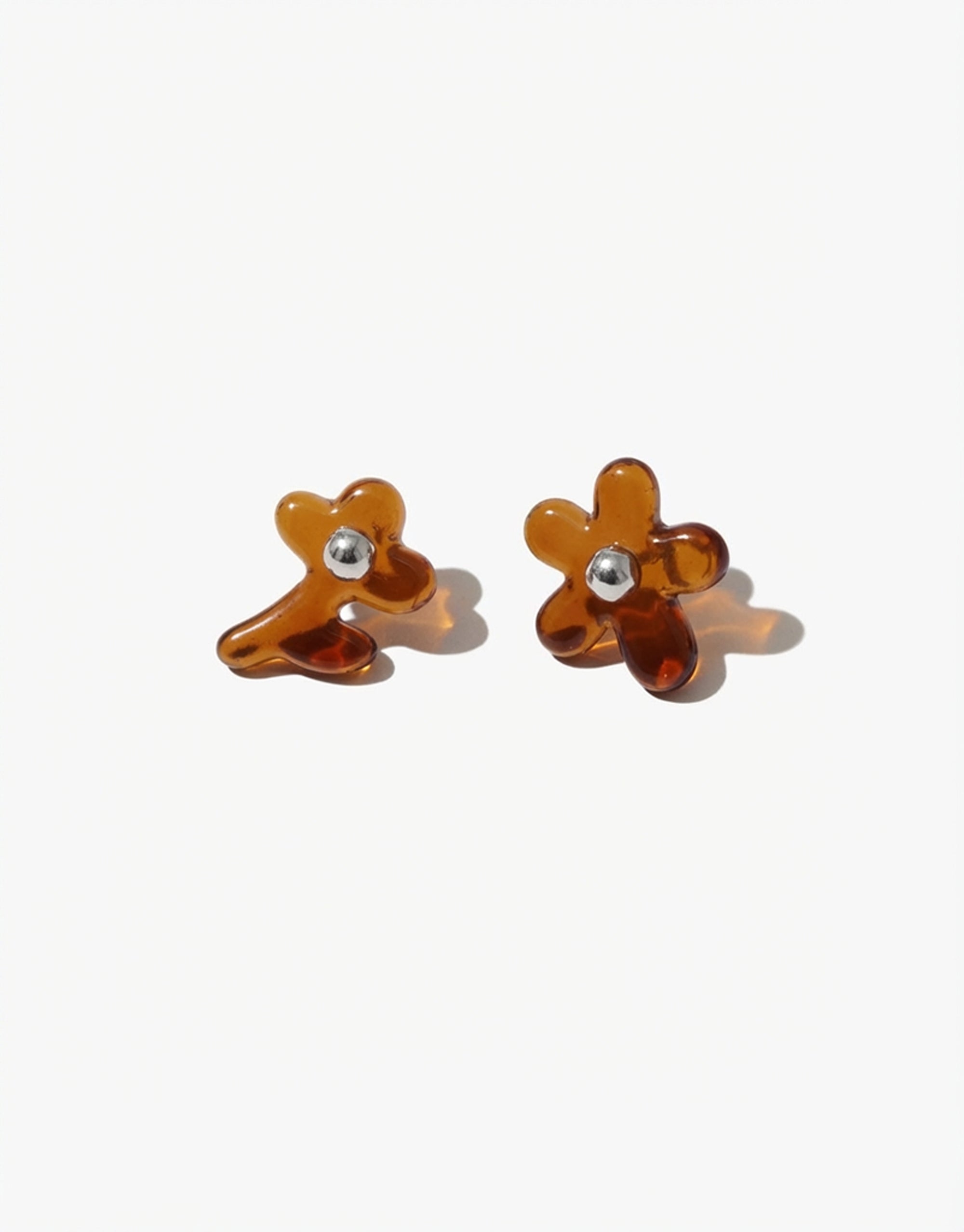 Pair of brown flower-shaped earrings on a white background