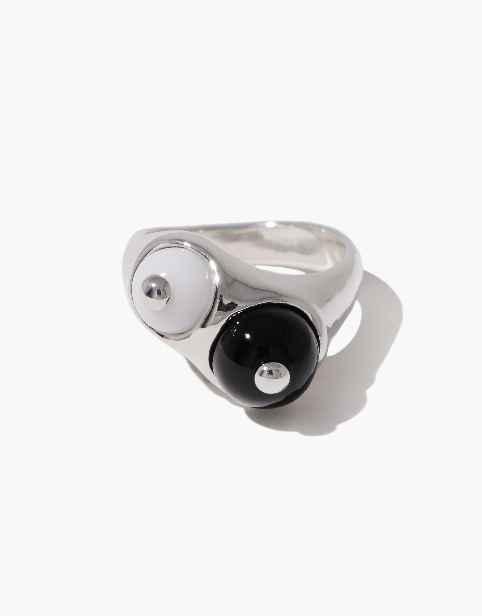 Sleek silver Pod Ring featuring two contrasting spheres, black and white, nestled in an organic, curvy design. Inspired by nature's legumes, this unique jewelry piece embodies growth and transformation. A perfect blend of modern style and natural elegance. Pod Ring by CLED