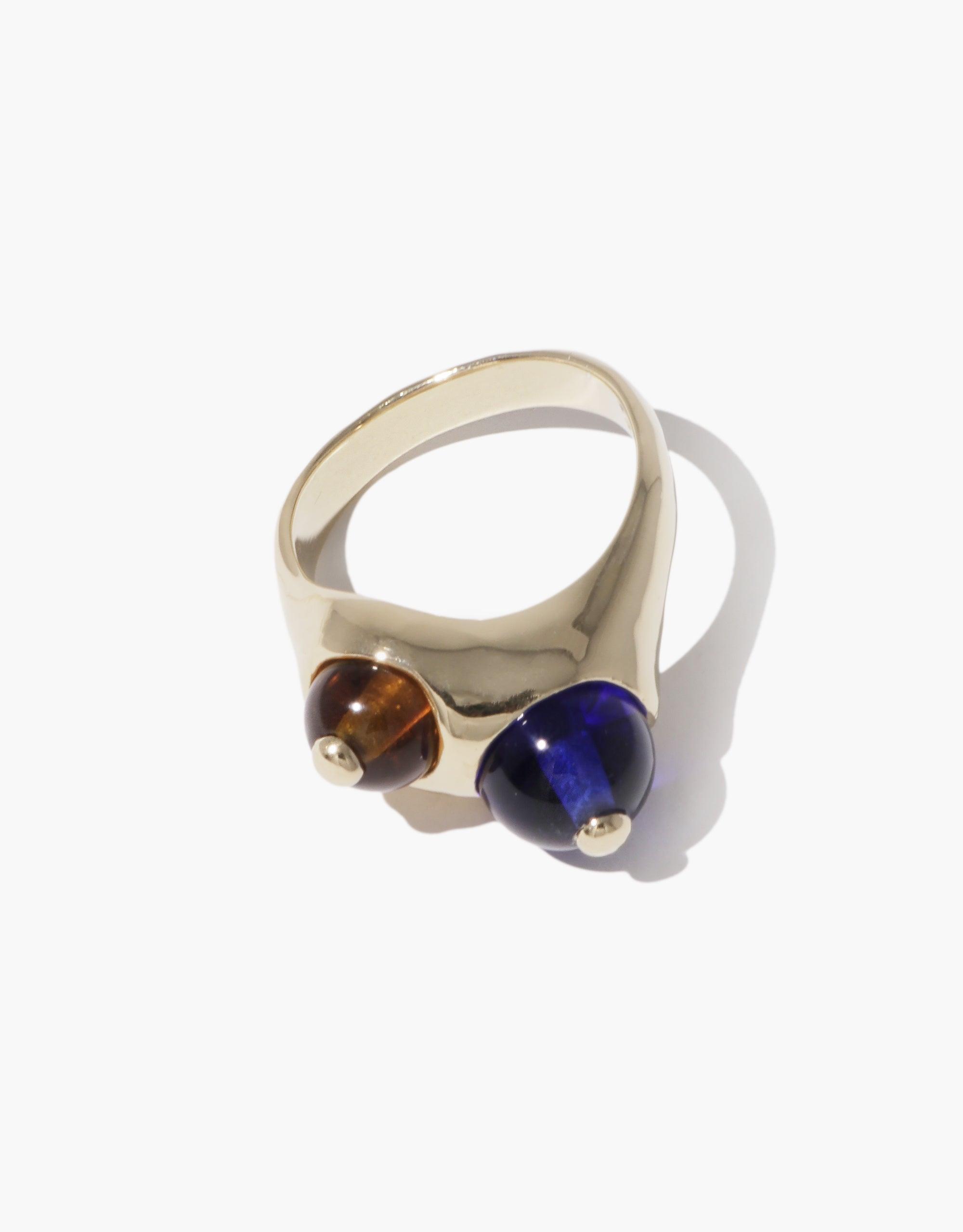 Elegant Pod Ring featuring dual orbs in contrasting brown and deep blue tones, set on a sleek gold-toned band. Inspired by nature's organic shapes, this unique piece embodies growth and transformation. A stylish accessory that captures the essence of natural beauty. CLED Pod Ring