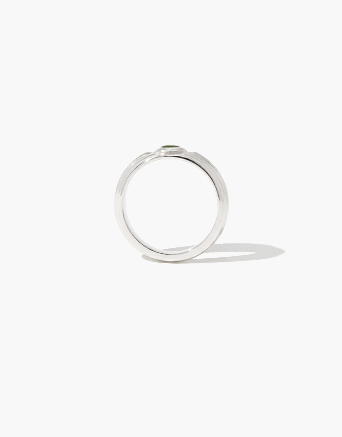 Close-up of the Eyelet Scallop Ring showing the scalloped silver frame around the green forest glass Eco Gem. Eyelet Scallop Ring by CLED.