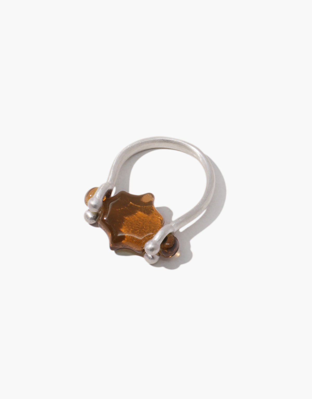 Las Swivel Ring | Scallop with a warm brown amber glass Eco Gem in a scalloped setting, turning between two silver beads. Las Swivel Ring | Scallop by CLED.