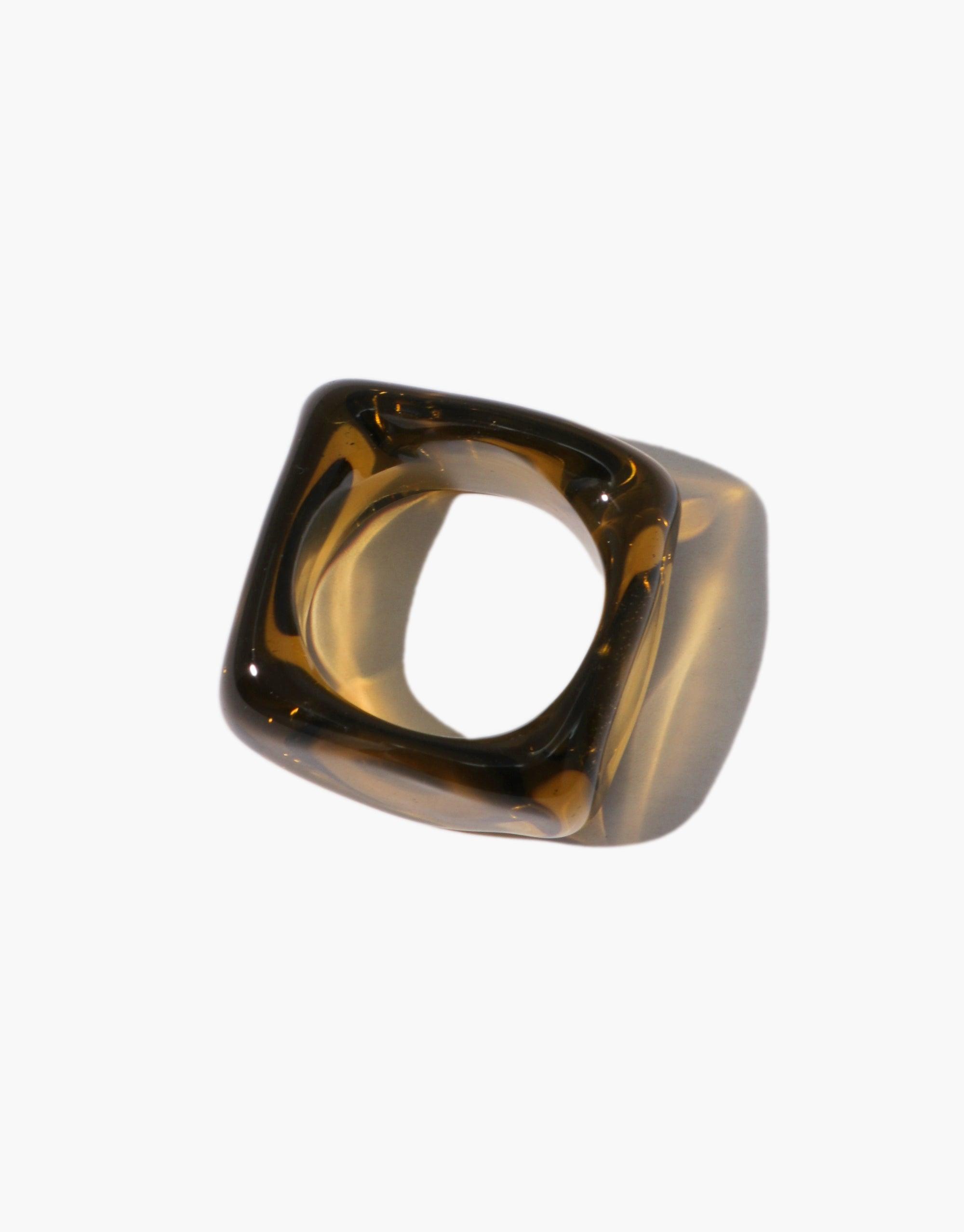 Engravable Dice Ring featuring a unique amber-colored transparent resin design with a square shape and hollow center. Four sides available for custom engraving. Sleek and modern jewelry piece for personalized style. CLED