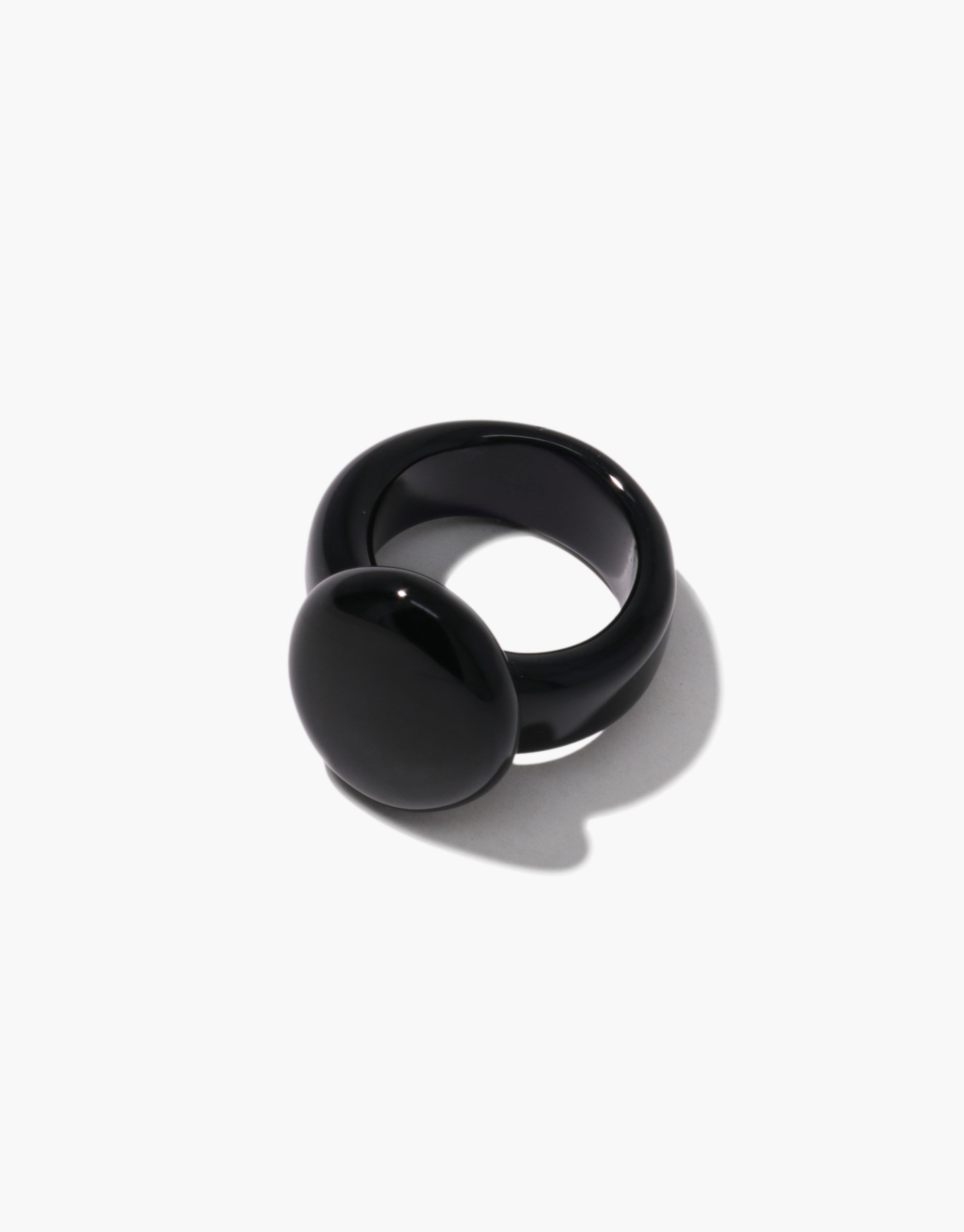 Front-facing view of a bold black ring featuring a smooth, rounded oval top and thick band design.