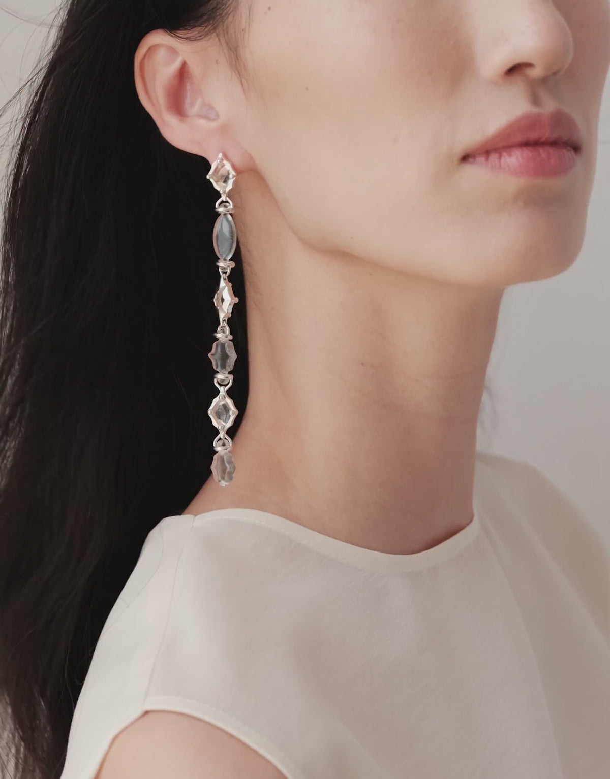 Cadence Linear Earring in clear glass swaying in a single long line of upcycled glass Eco Gems and sterling silver. Cadence Linear Earring by CLED.