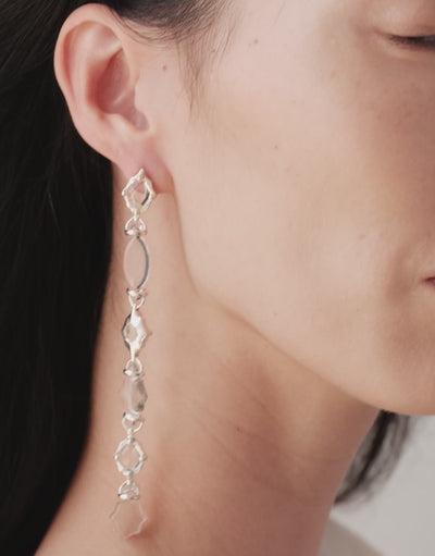 Cadence Linear Earring in clear glass turning with the head, graduating Eco Gems catching the light. Cadence Linear Earring by CLED.