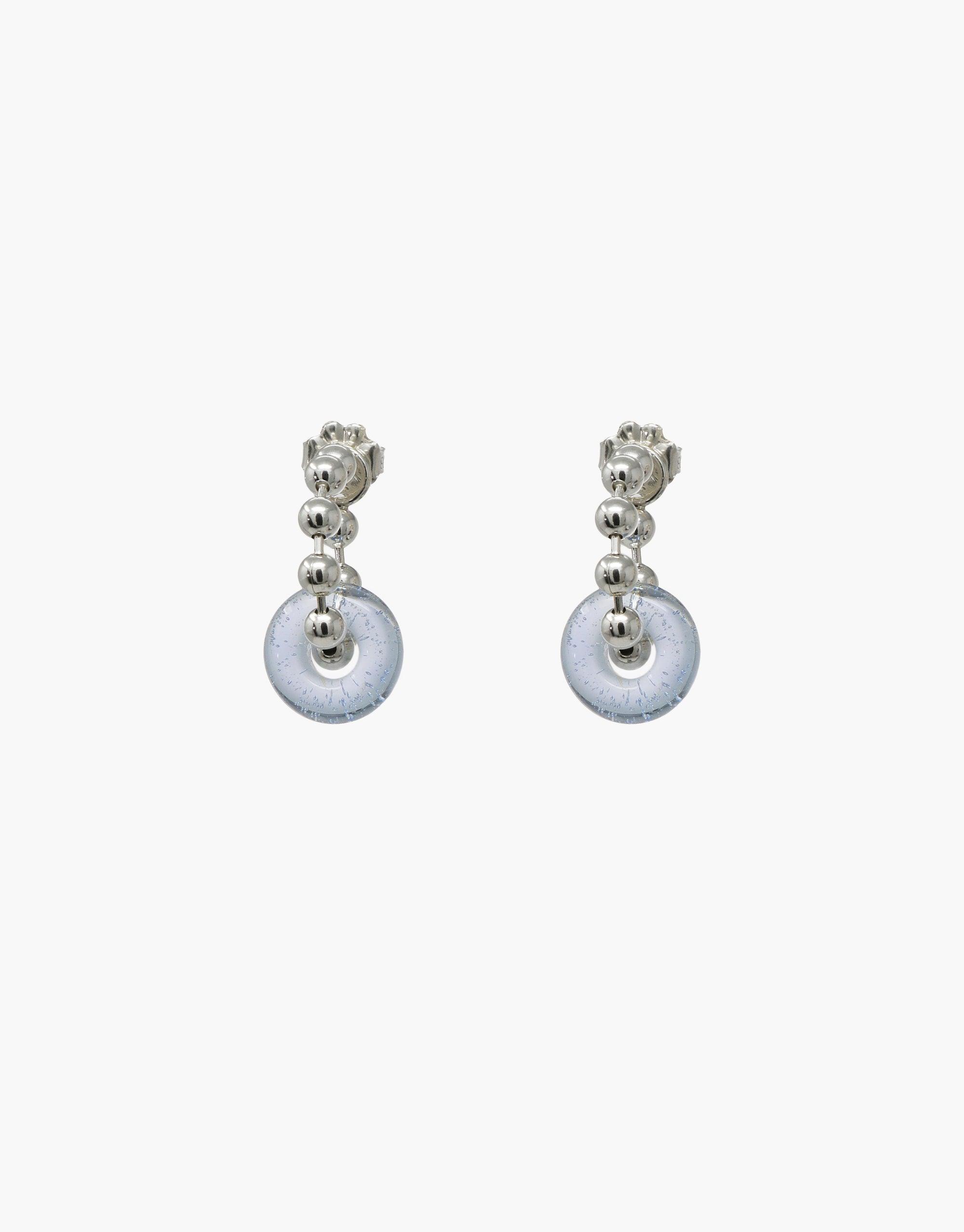 Donut Ball Hoop Earrings featuring silver-toned metal with dangling circular eco gems in light blue. Elegant and sustainable design showcasing upcycled glass. Perfect for eco-conscious fashion lovers. Handcrafted with precision for a unique, prismatic effect. CLED Donut Ball Hoop Earrings.