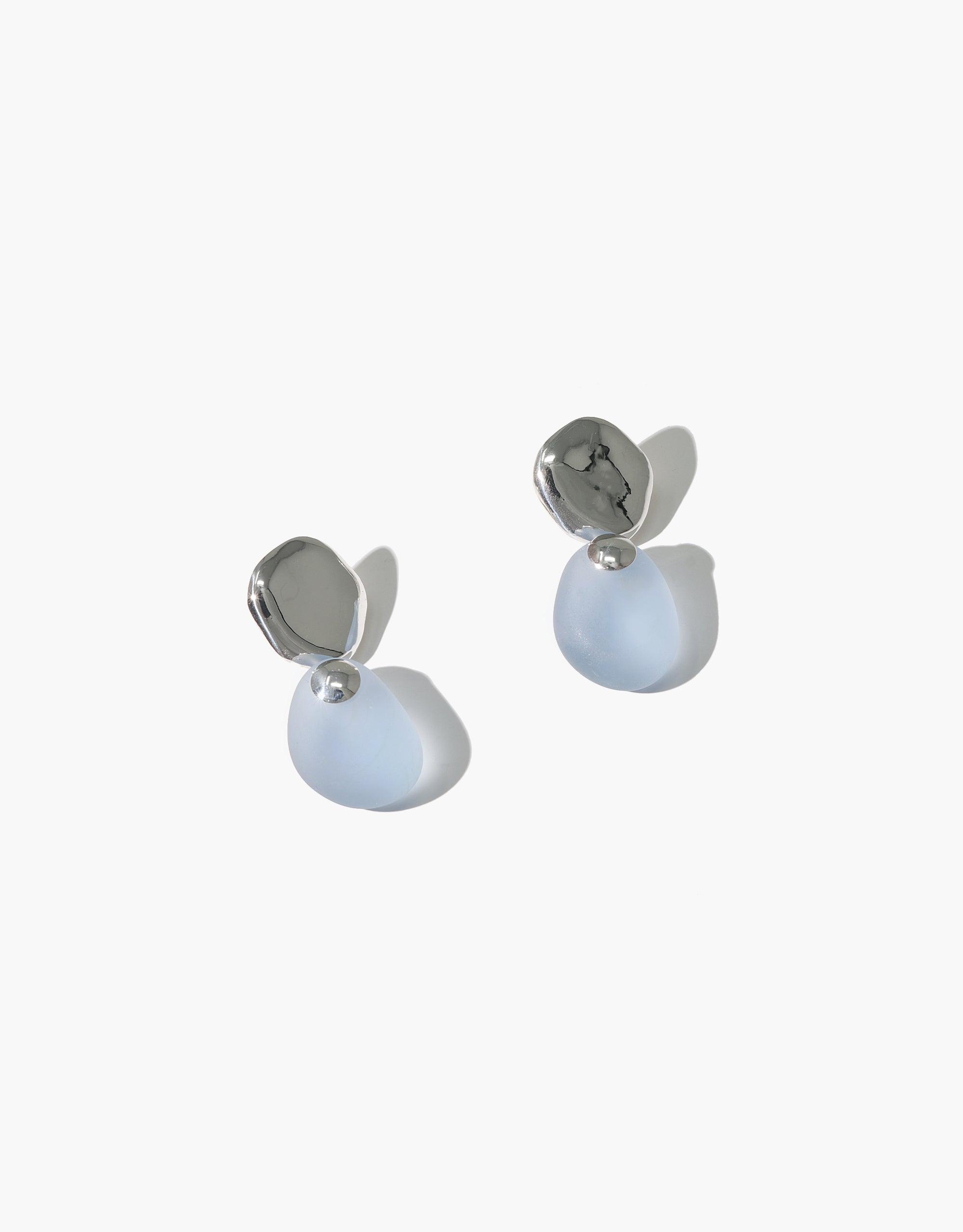 Elegant Pebble Earrings featuring silver-toned studs and translucent pale blue glass drops. Handcrafted eco-friendly jewelry with a modern, minimalist design. Perfect for everyday wear or special occasions. Sustainable and stylish accessory by CLED. Pebble Earrings.