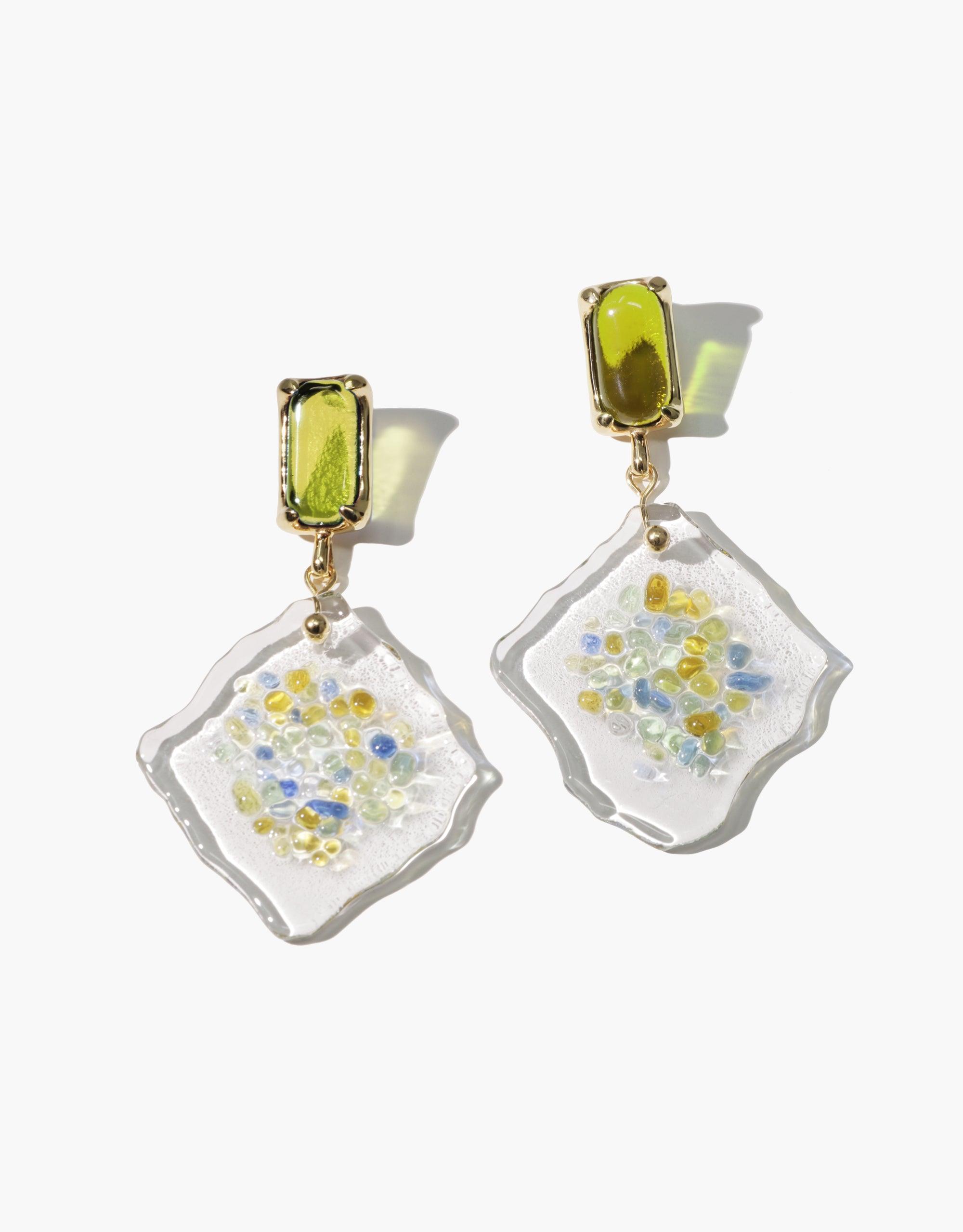 Spectral Prism Earrings featuring hand-formed eco gems with yellow and blue speckles in clear glass, suspended from lime-green rectangular studs. Unique, sustainable jewelry showcasing upcycled glass bottles, reflecting prism-like colors. Handmade statement piece by CLED.