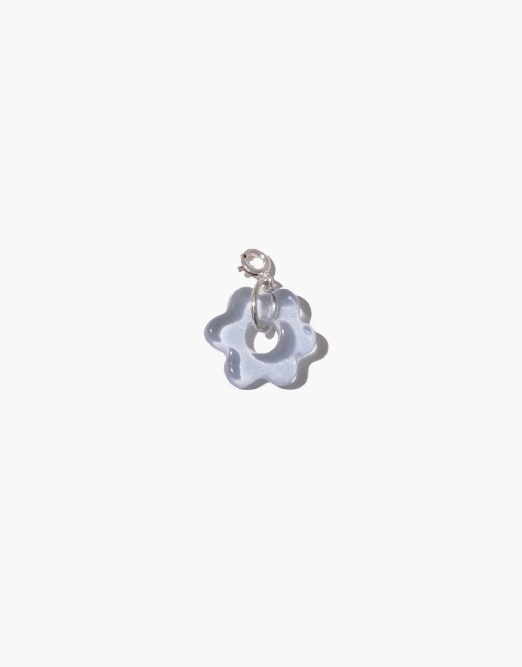 Delicate flower-shaped charm in translucent blue glass with silver attachment, showcasing handcrafted detail. Avens Icon Charm by CLED, perfect for personalizing necklaces or bracelets with eco-friendly elegance.