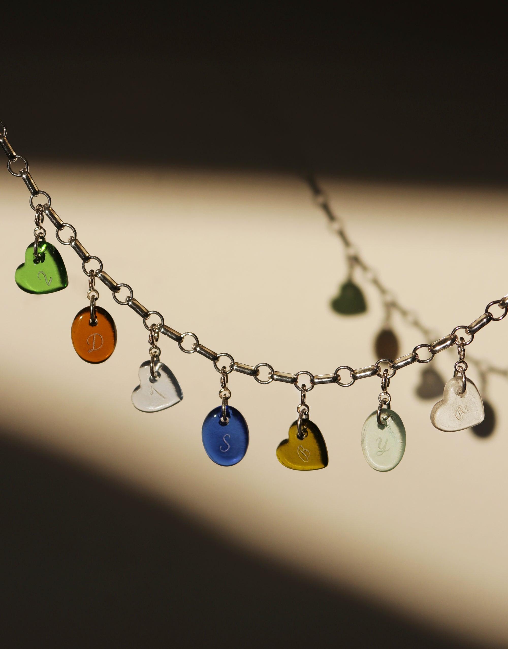 Silver chain bracelet with colorful heart and round icon charms in green, orange, blue, yellow, and clear glass, showcasing the Heart | Icon Charm product. Handmade eco-friendly jewelry by CLED.