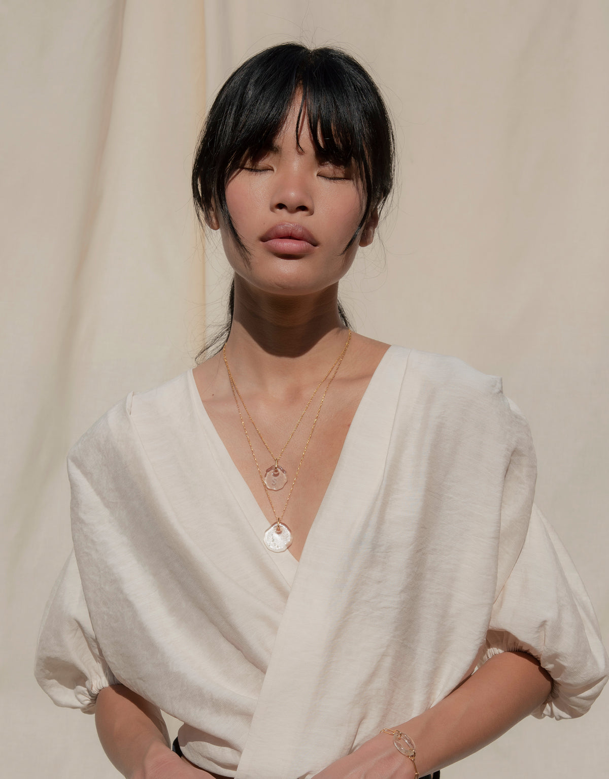 Elegant model wearing Constellation Necklace, featuring delicate glass pendant with engraved zodiac symbols on adjustable chain. Eco-friendly jewelry showcasing sustainable luxury and celestial design. Perfect for expressing connection and love. Handmade in Los Angeles by CLED.
