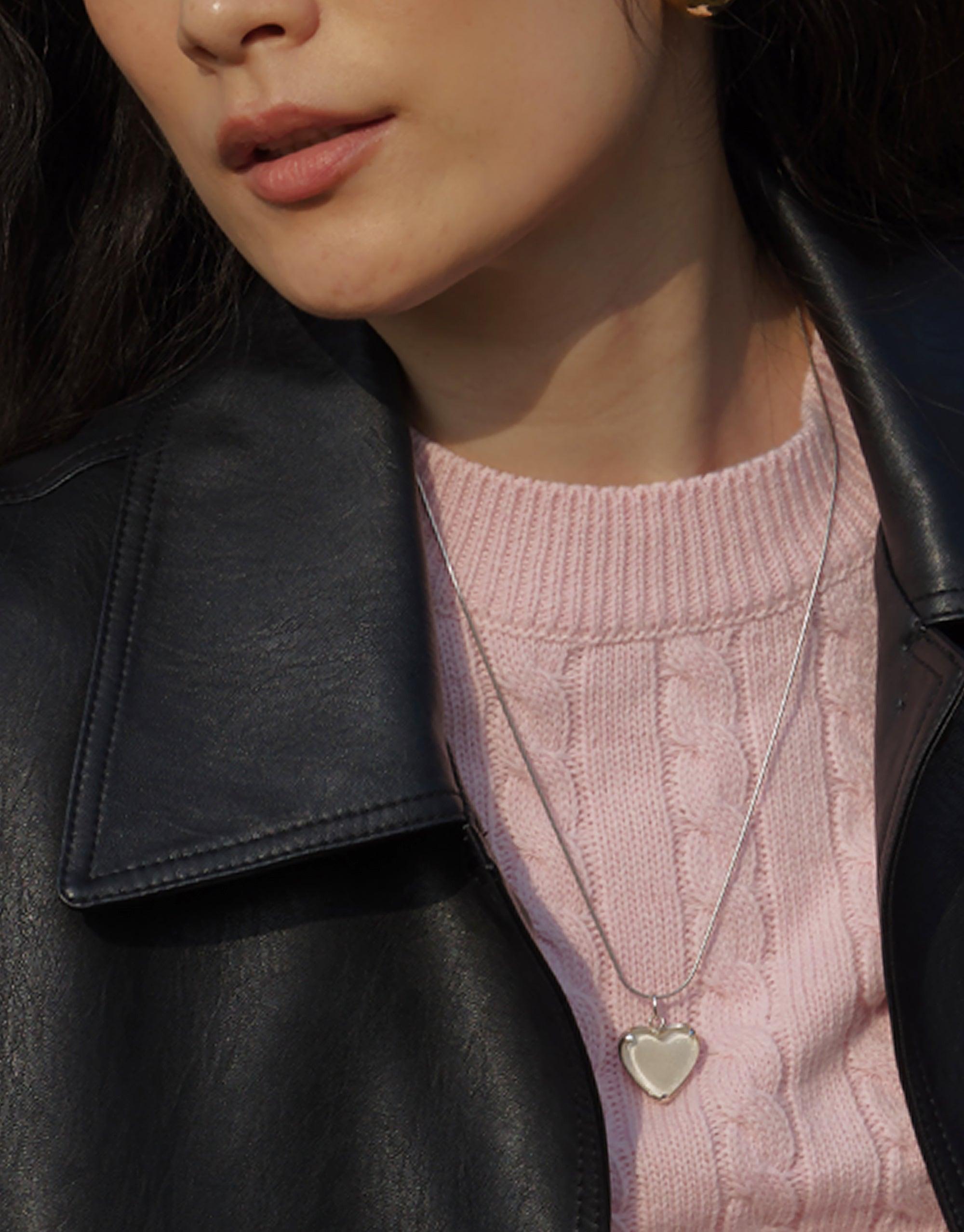 Elegant Heart Frame Long Necklace on model wearing pink sweater and black leather jacket, showcasing delicate charm pendant. Sustainable jewelry piece with adjustable chain length, handcrafted from upcycled materials. CLED Heart Frame Long Necklace