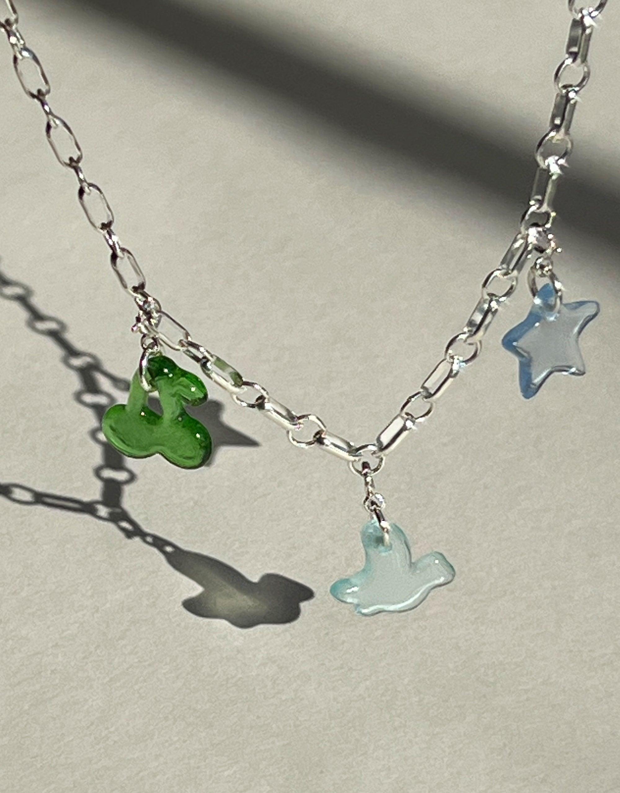 Silver chain necklace with colorful glass charms including a green cherry, blue star, and light blue ghost, showcasing the Cherry Icon Charm collection. Upcycled eco-friendly jewelry handmade with sustainable materials. CLED, Cherry | Icon Charm