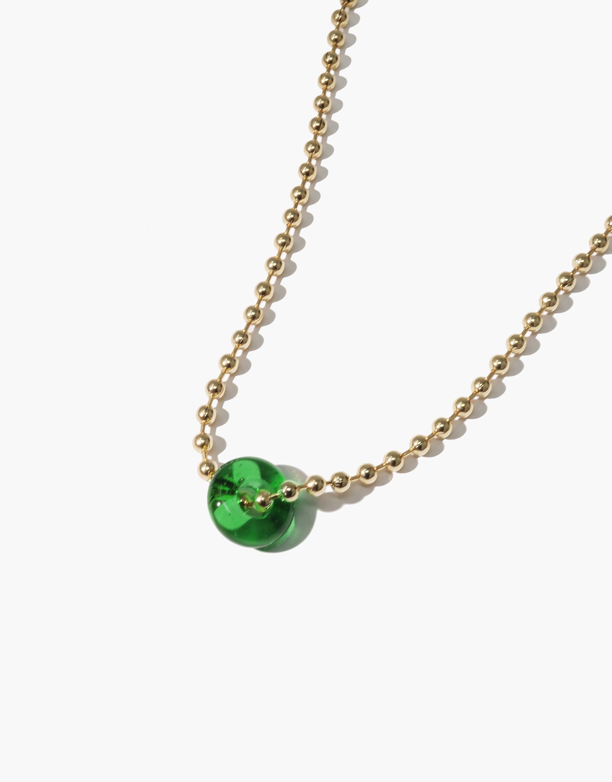 Elegant Donut Ball Necklace featuring a vibrant green eco gem bead on a delicate gold chain, showcasing sustainable luxury and prismatic beauty. Handcrafted jewelry piece from CLED's Rays of Light collection.