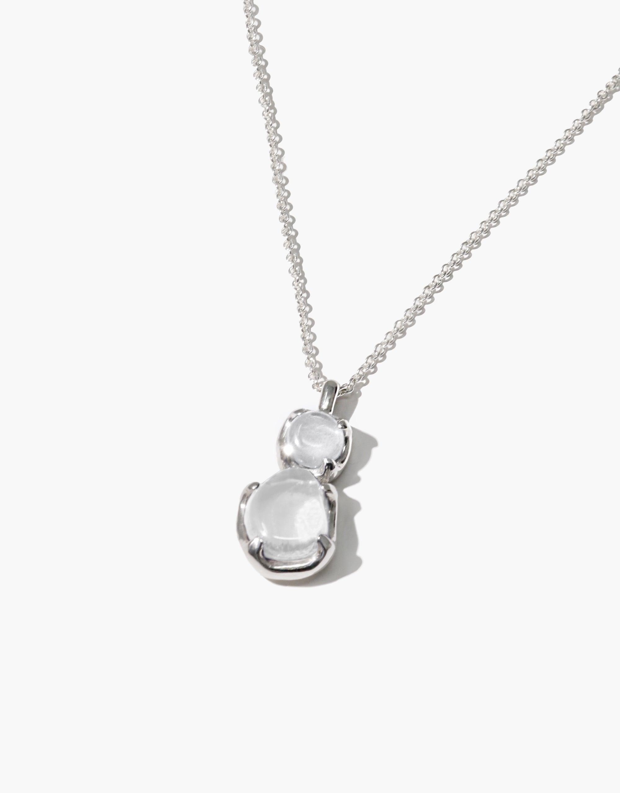 Elegant Duo Beam Necklace featuring two stacked clear eco gems on a delicate silver chain, showcasing sustainable luxury and prismatic light effects. Handcrafted pendant reflects CLED's commitment to upcycled materials and eco-friendly jewelry design. Duo Beam Necklace by CLED.