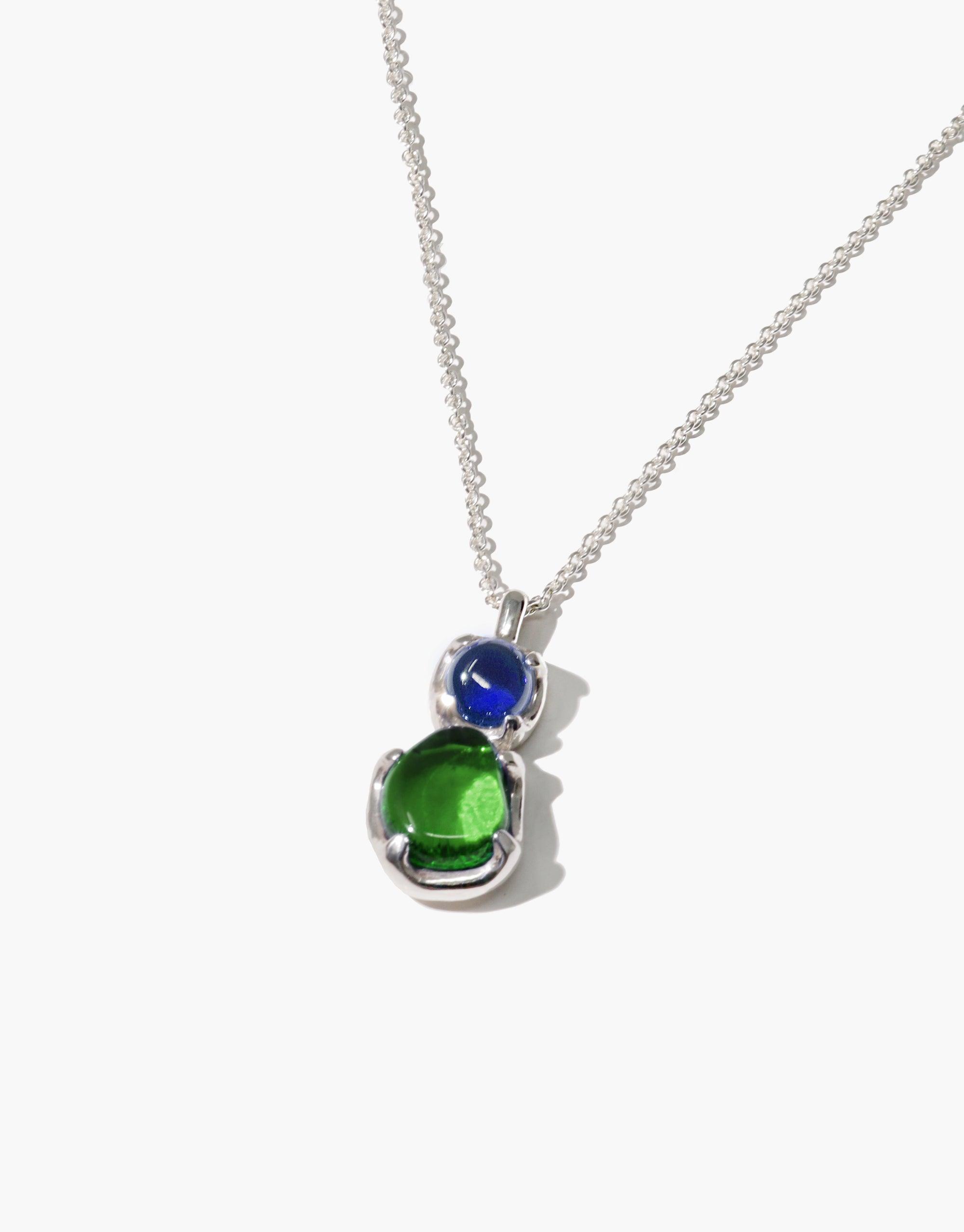 Elegant Duo Beam Necklace featuring a pendant with blue and green eco gems, crafted from upcycled glass, suspended on a delicate silver chain. Showcasing sustainable beauty and prismatic colors inspired by natural light refraction. Handmade by CLED.