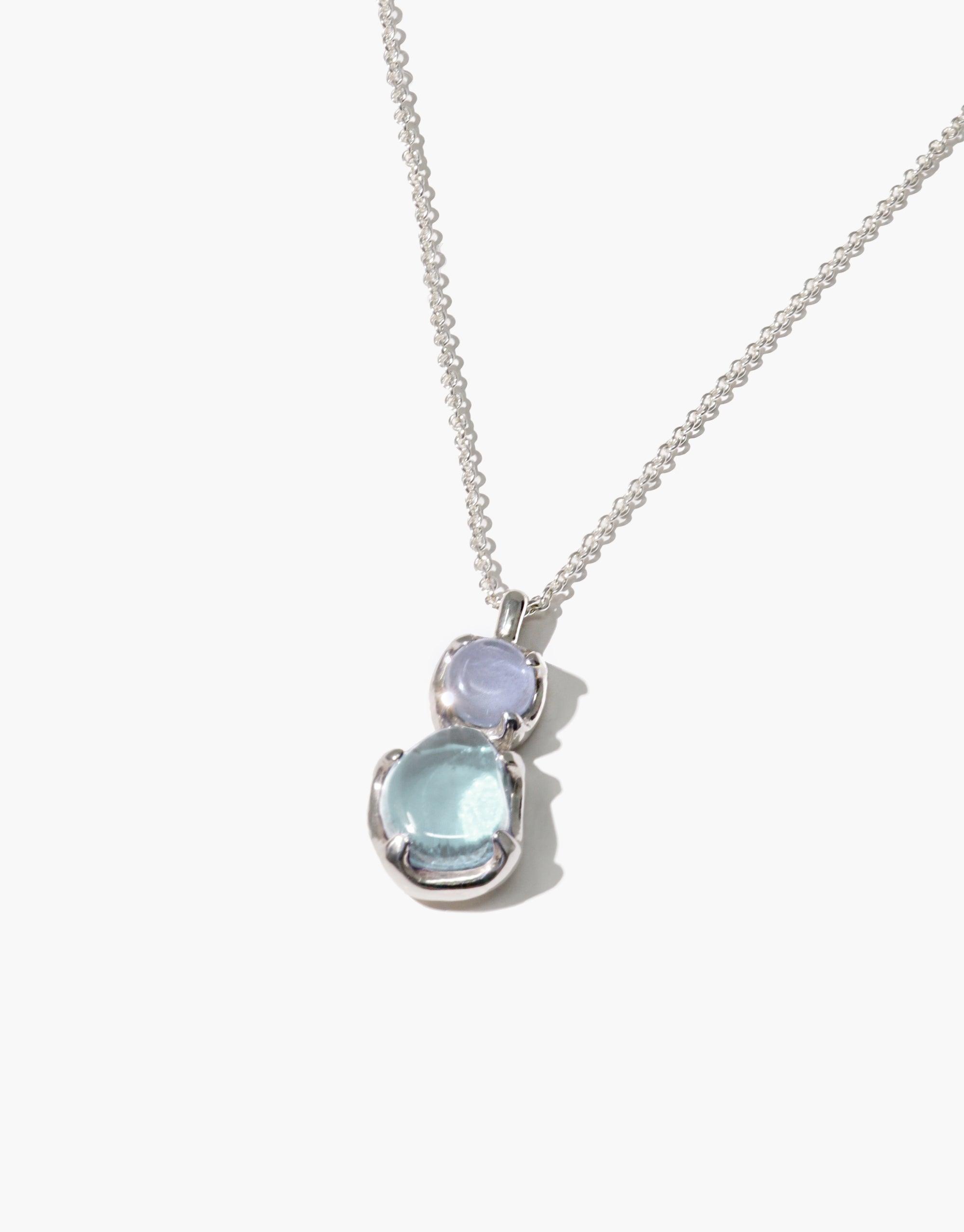 Elegant Duo Beam Necklace featuring two prismatic eco gems in soft blue hues, handcrafted from upcycled glass, suspended on a delicate silver chain. A sustainable and stylish accessory that captures the essence of light refraction. Duo Beam Necklace by CLED.