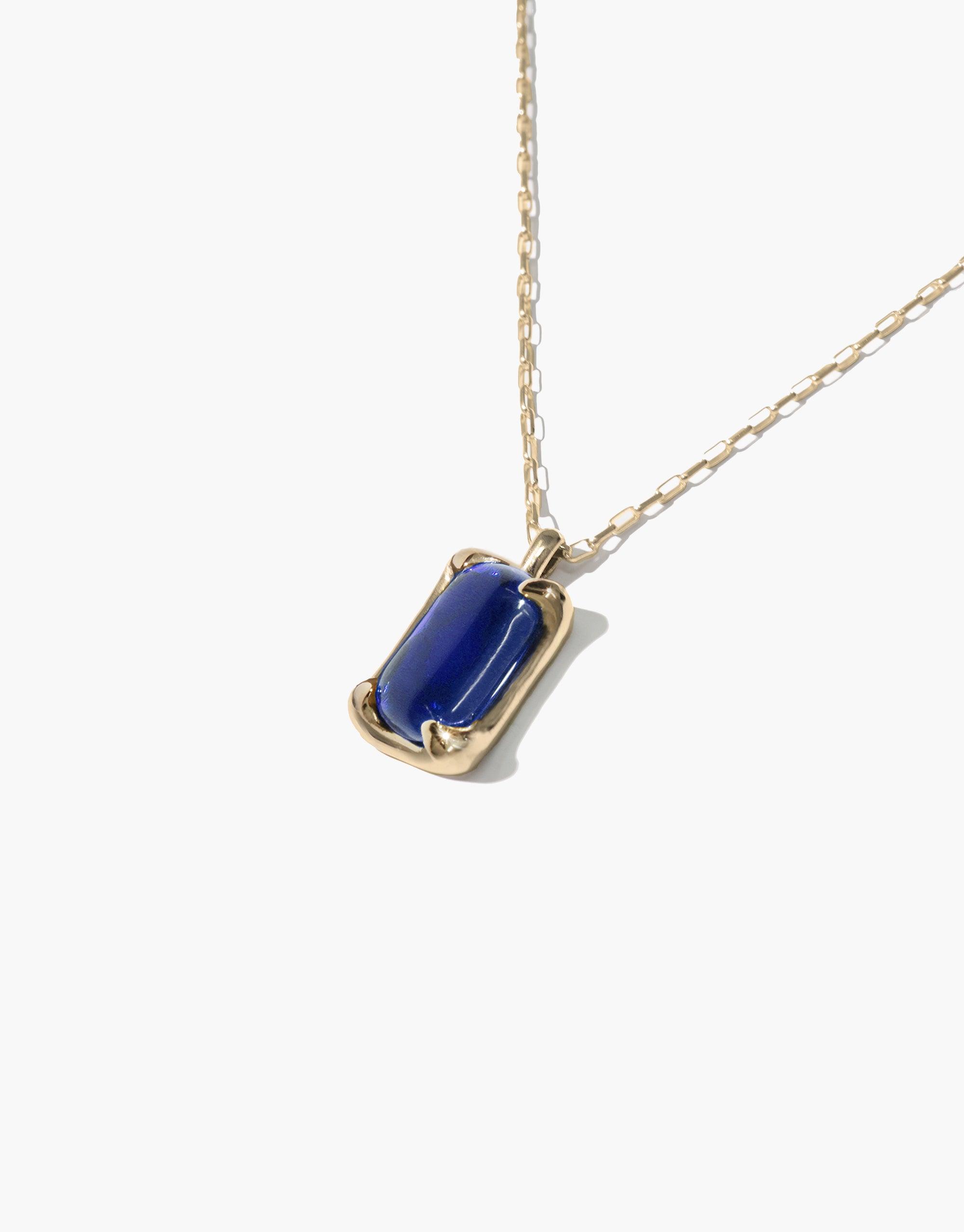 Elegant Prism Necklace featuring a deep blue rectangular eco gem pendant on a delicate gold chain. Handcrafted sustainable jewelry showcasing upcycled glass in a minimalist design. Perfect for adding a pop of color to any outfit. CLED Prism Necklace.