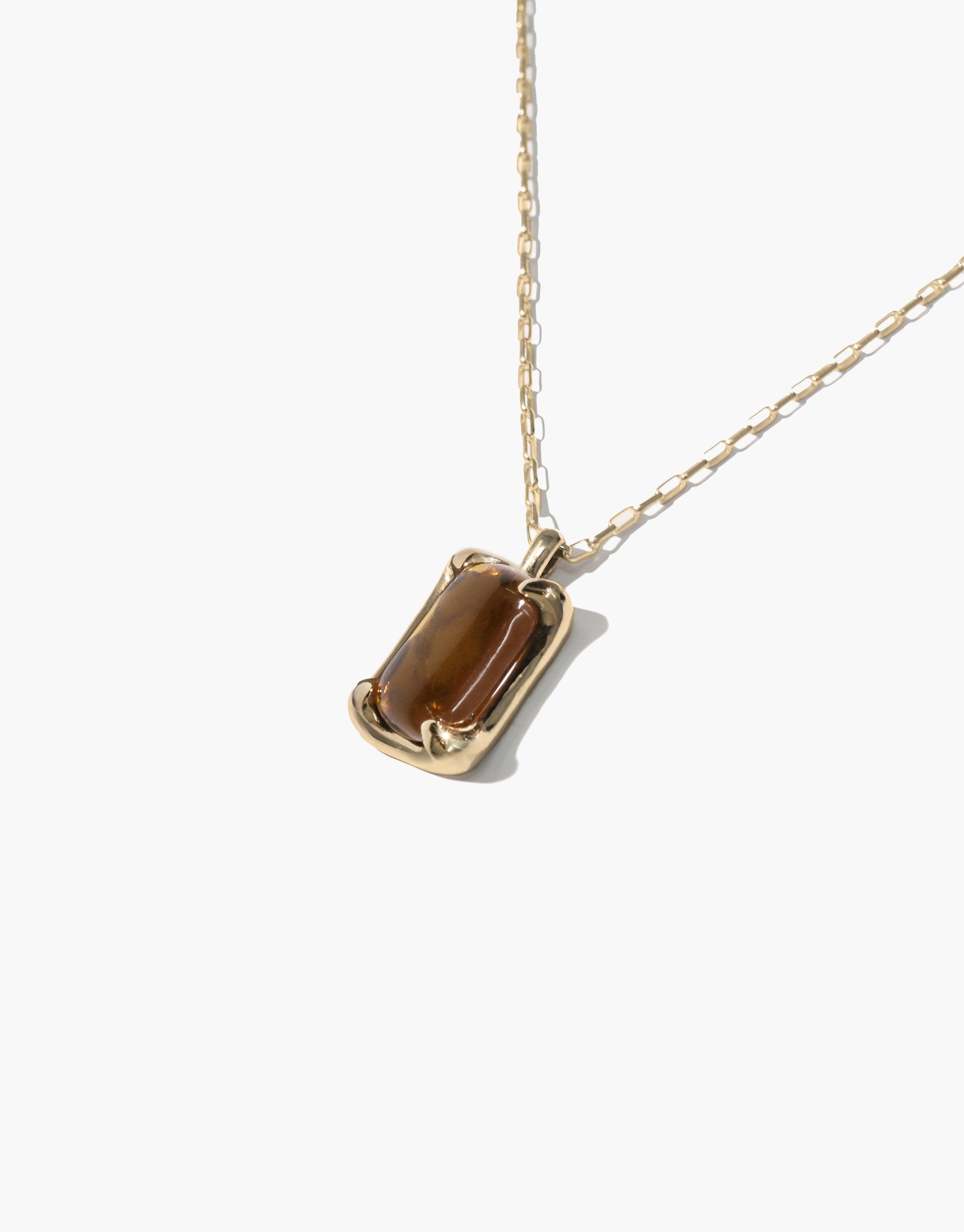 Prism Necklace featuring a golden chain with a rectangular pendant showcasing a brown eco gem repurposed from discarded glass, reflecting sustainable luxury and spectral colors inspired by natural light refraction, handcrafted in Los Angeles by CLED