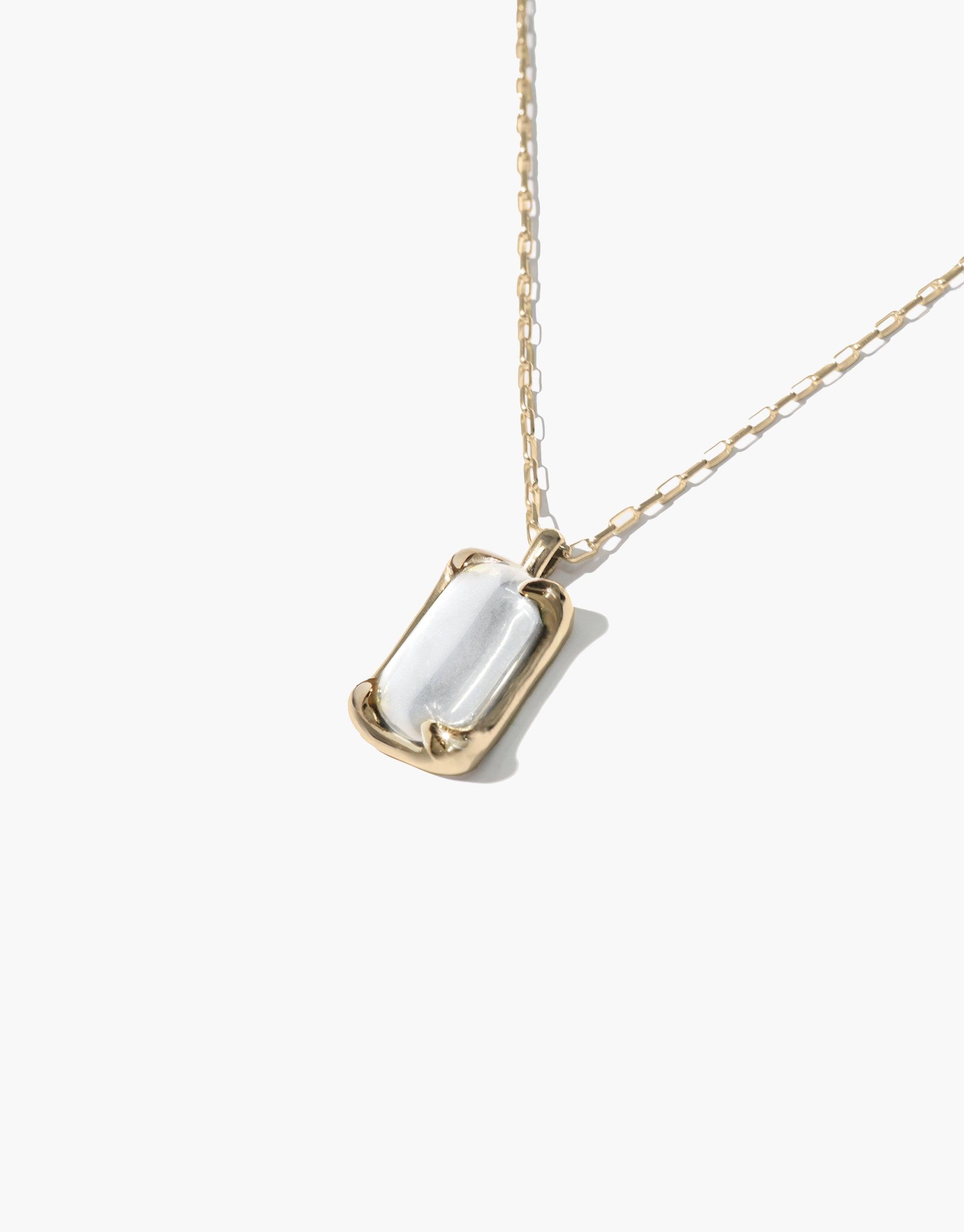 Elegant Prism Necklace featuring a rectangular eco gem pendant in gold-toned setting, suspended on a delicate chain. Handcrafted from upcycled glass, this sustainable jewelry piece captures light beautifully. Prism Necklace by CLED.