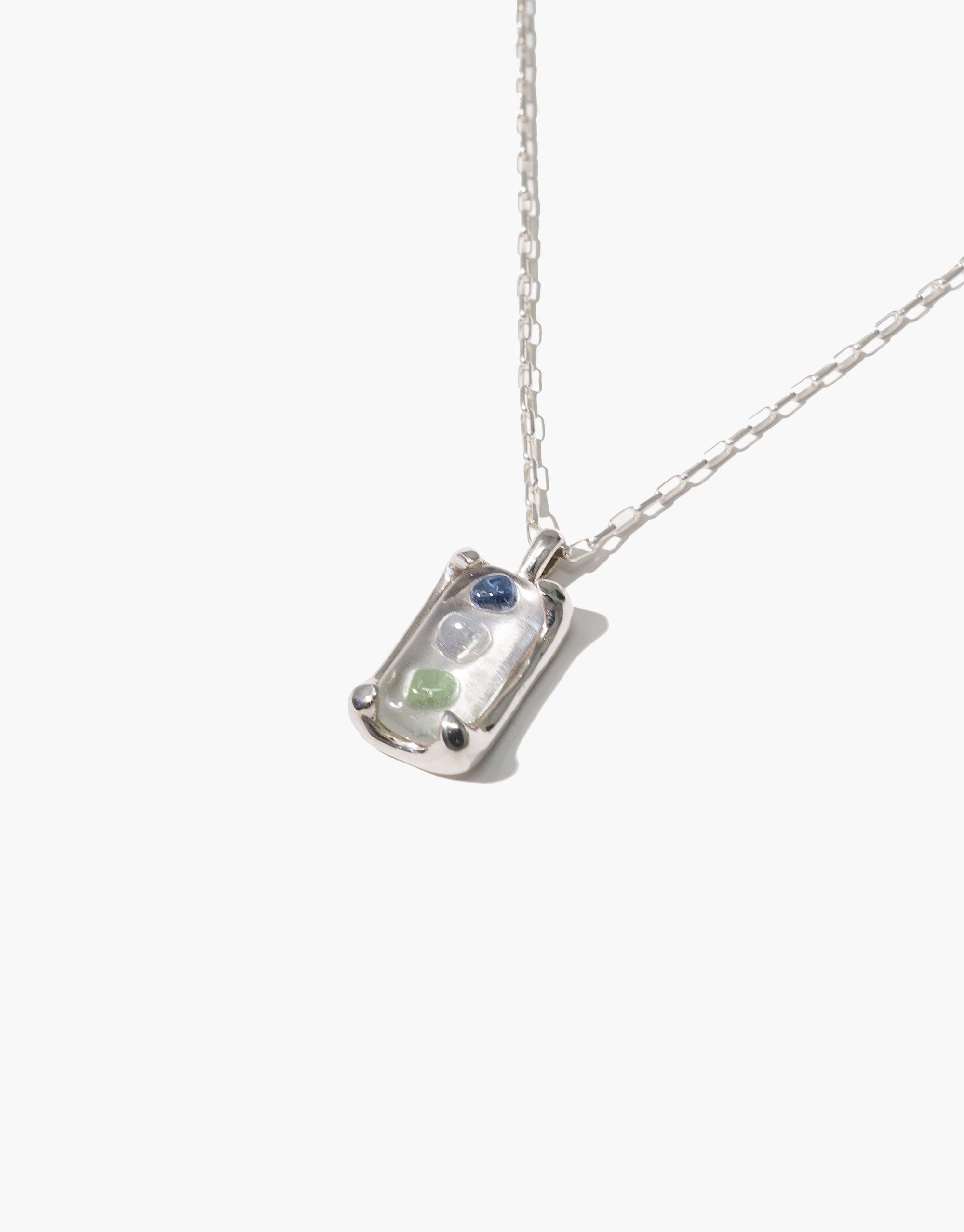 Prism Necklace featuring a sterling silver pendant with blue and green eco gems made from upcycled glass, suspended on a delicate chain. Handcrafted sustainable jewelry inspired by light refraction, showcasing CLED's commitment to eco-friendly design. Prism Necklace by CLED.
