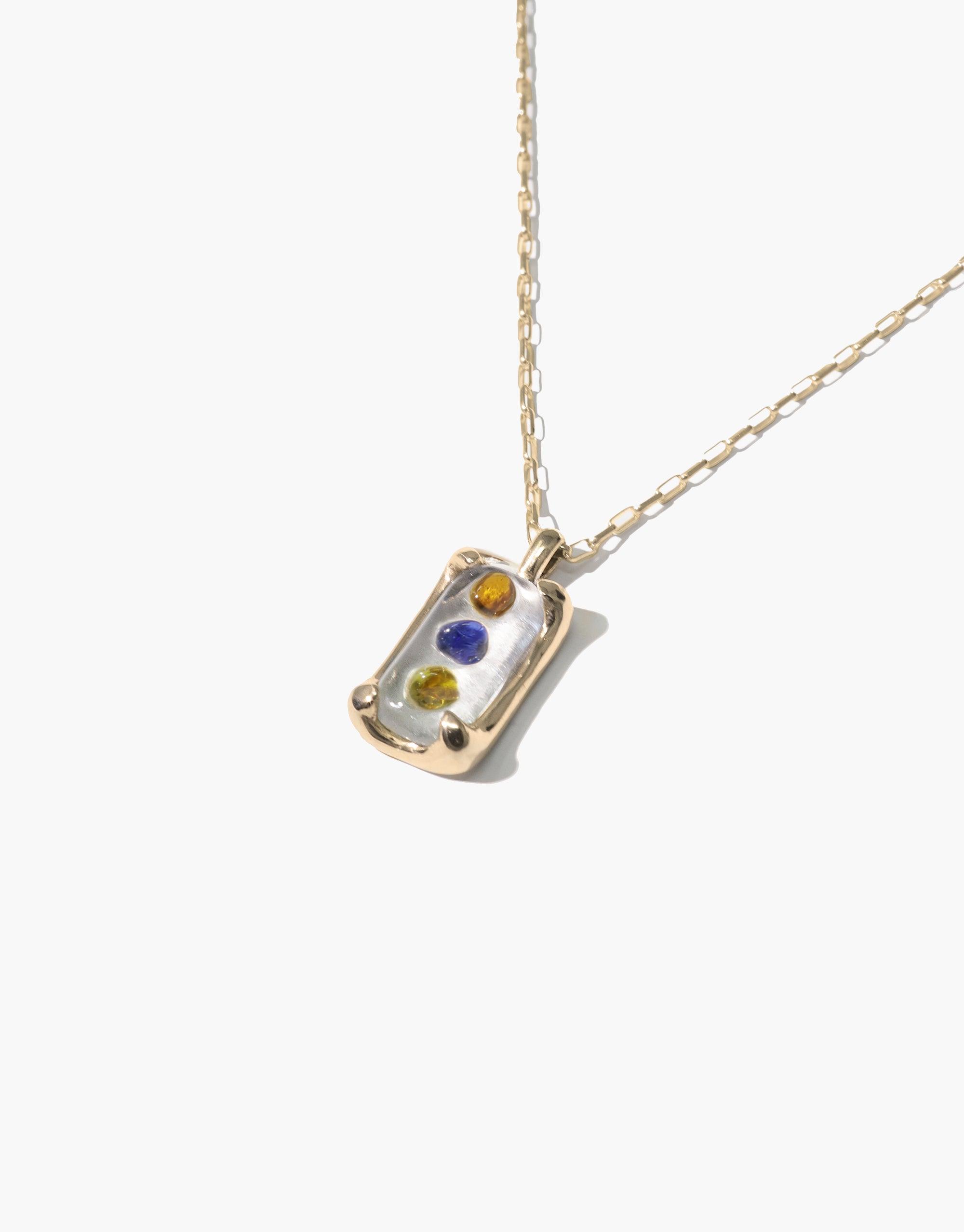 Prism Necklace featuring a rectangular pendant with colorful eco gems upcycled from discarded glass, suspended on a delicate gold chain. Handcrafted jewelry showcasing sustainable design and prismatic light effects. Elegant and eco-friendly accessory by CLED.
