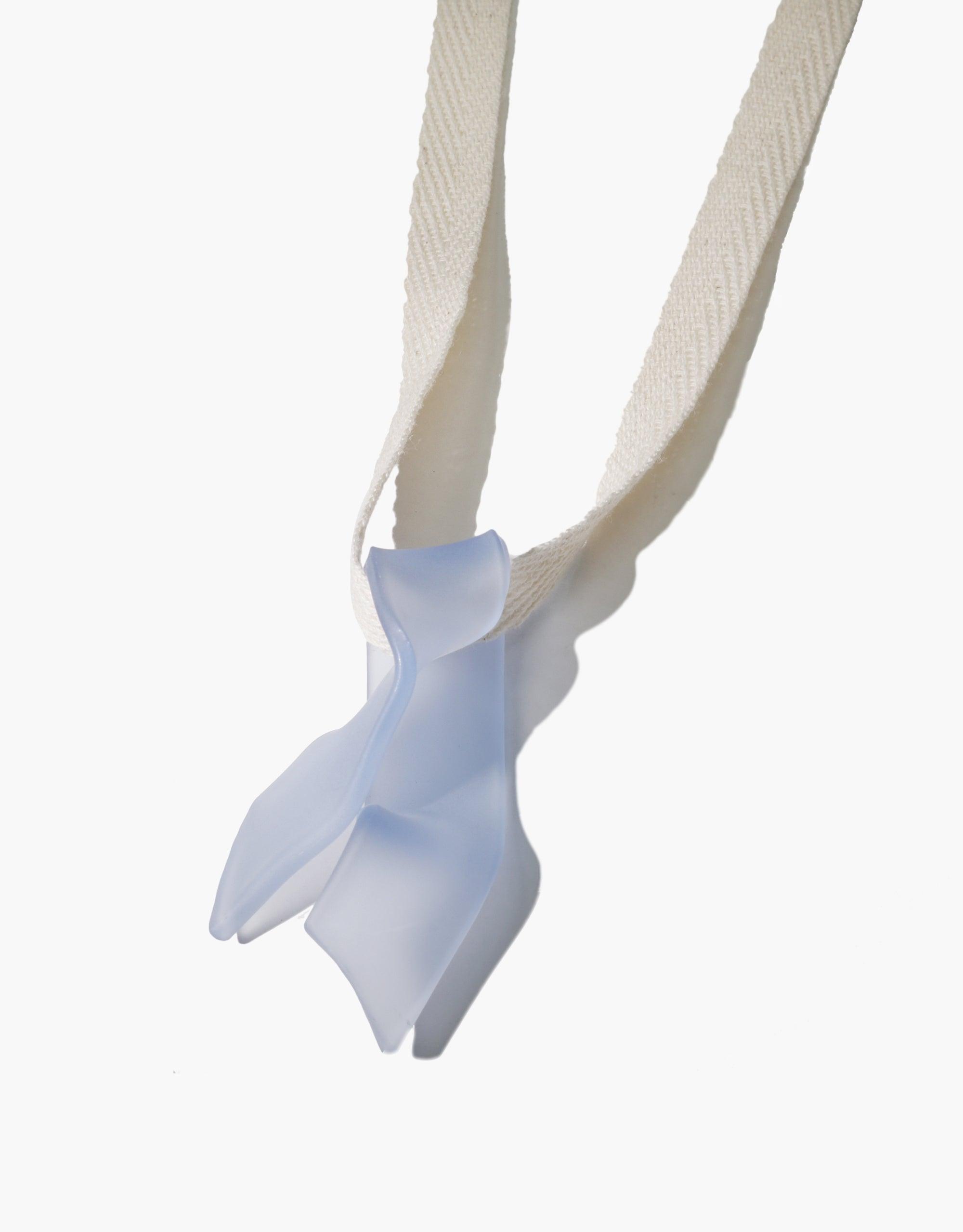 Ribbon Necklace featuring a handcrafted serpentine-shaped eco gem pendant in light blue, suspended on a white cotton ribbon. Unique, sustainable jewelry design showcasing repurposed glass. Elegant and eco-friendly accessory. CLED