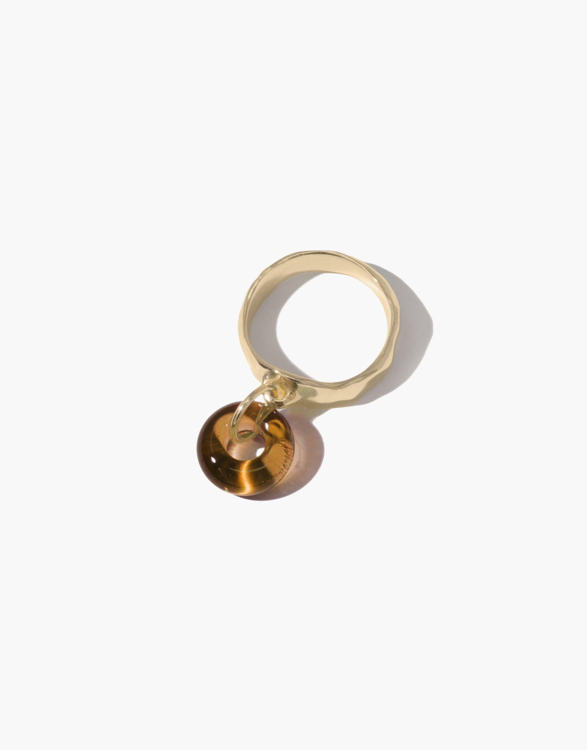Gold-toned ring with amber-colored glass charm, showcasing circular design. Handcrafted eco-friendly jewelry piece. Donut Dangling Ring by CLED.