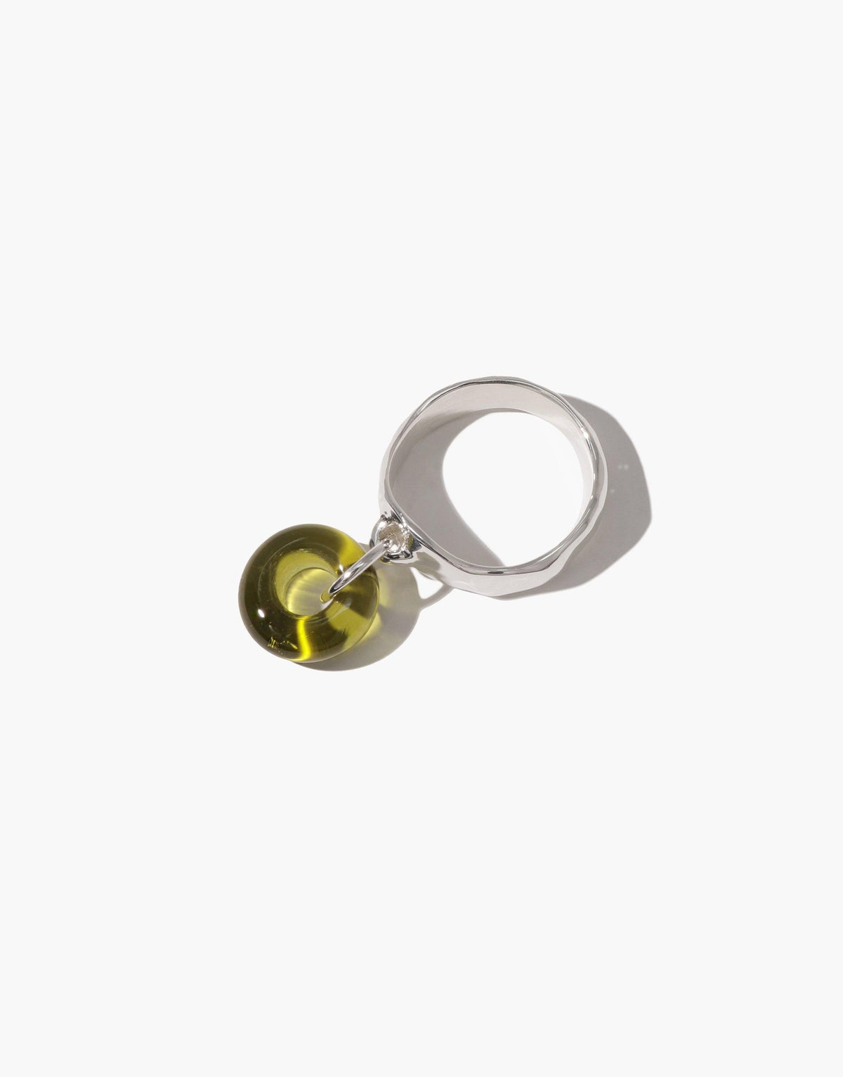 Donut Dangling Ring featuring a sterling silver band with a translucent olive green eco gem charm. Handcrafted jewelry piece showcasing sustainable design and unique aesthetics. Ideal for eco-conscious fashion enthusiasts. CLED