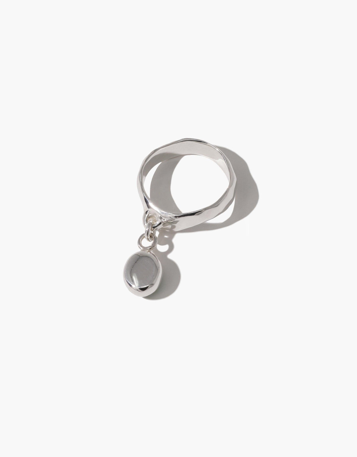 Oval Dangling Ring featuring a sleek silver band with a unique oval-shaped charm hanging from it. Handcrafted eco-friendly design made from upcycled glass, showcasing elegant simplicity and sustainable style. Available in sterling silver or gold-plated brass. Oval Dangling Ring by CLED.