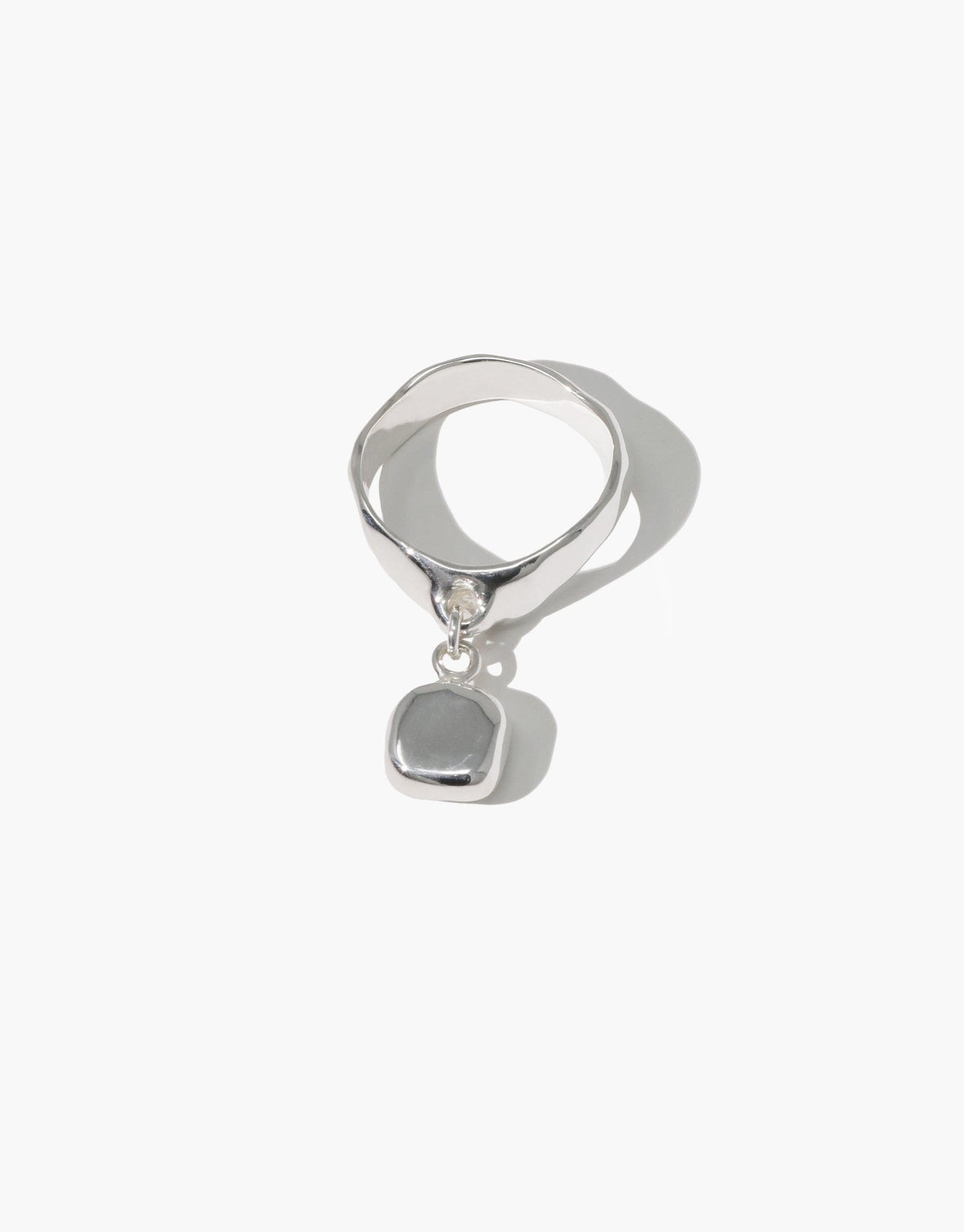 Square Dangling Ring featuring a silver band and a square pendant, showcasing a repurposed Eco Gem. A handmade piece reflecting CLED's eco-conscious jewelry ethos.