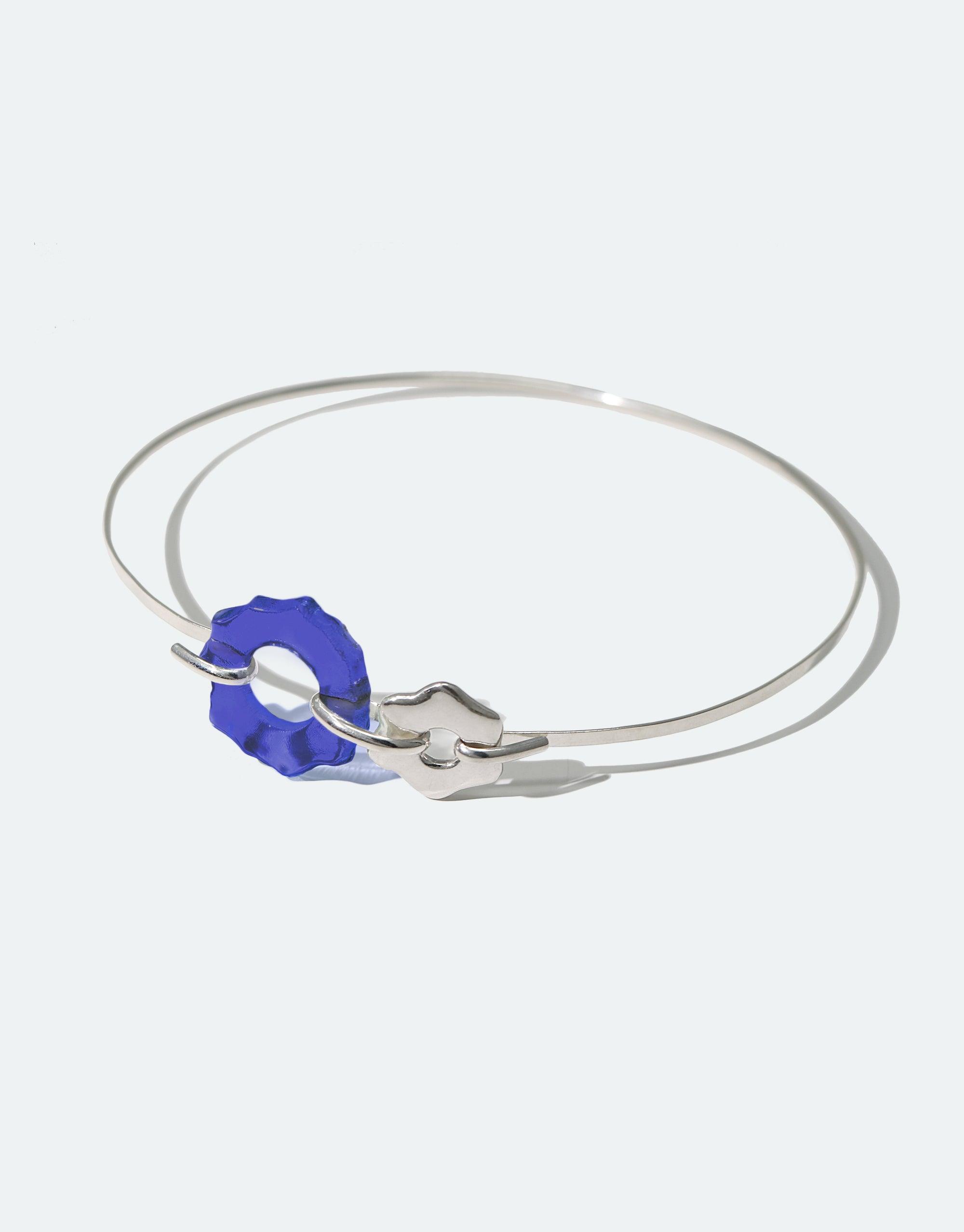 Elegant Avens Choker Necklace featuring a delicate silver wire with a blue glass flower pendant and silver flower charm, inspired by Arctic flora. Eco-friendly jewelry made from repurposed glass. Minimalist design suitable for day to evening wear. Handcrafted sustainable accessory by CLED.