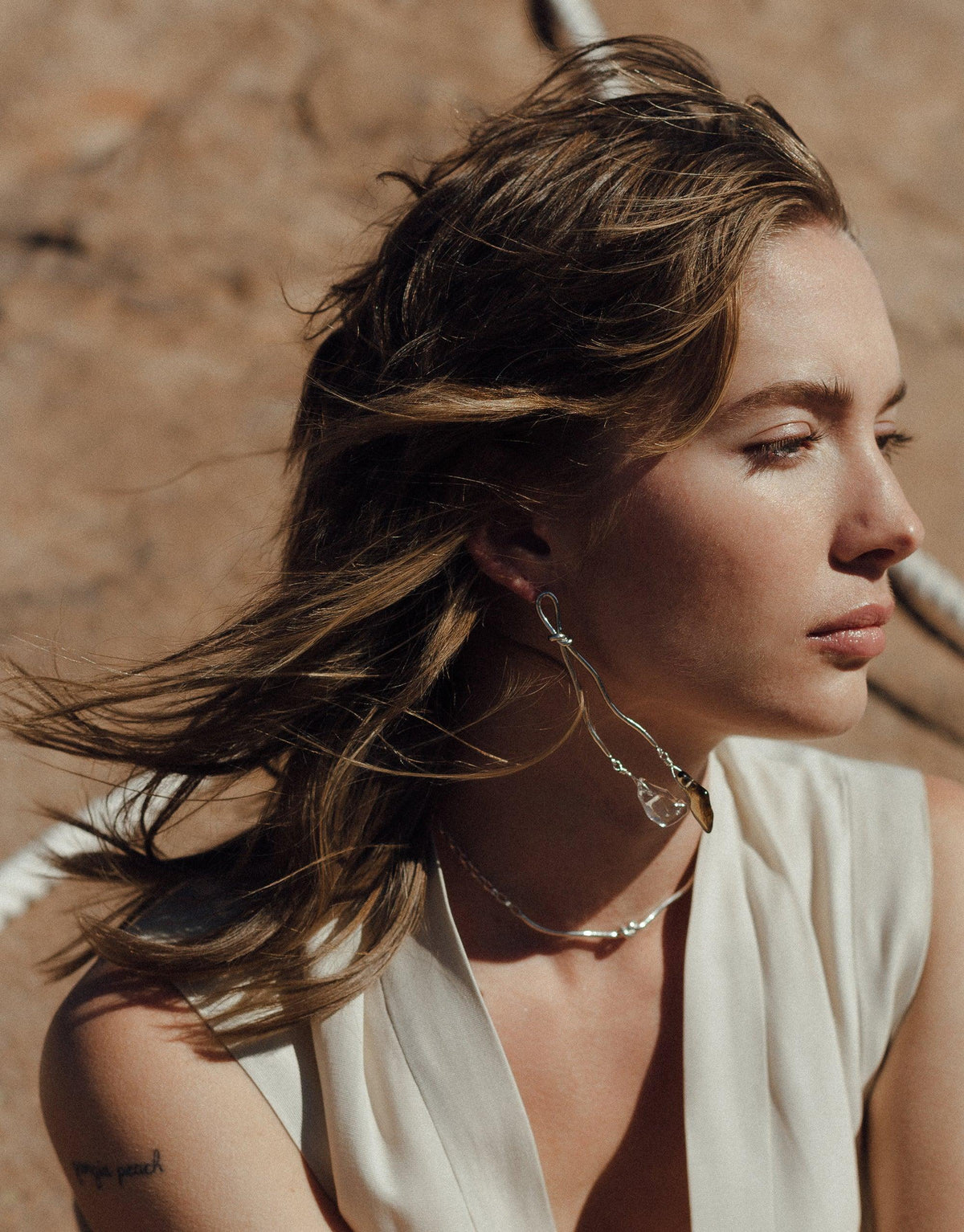 Model wearing Rope Drop Earrings, showcasing long, silver abstract designs inspired by canyon terrain and rock climbing ropes. Eco Gem drops add elegance to the handcrafted earrings. Part of the Terrain Collection by CLED, these Rope Drop Earrings blend sustainability with style.