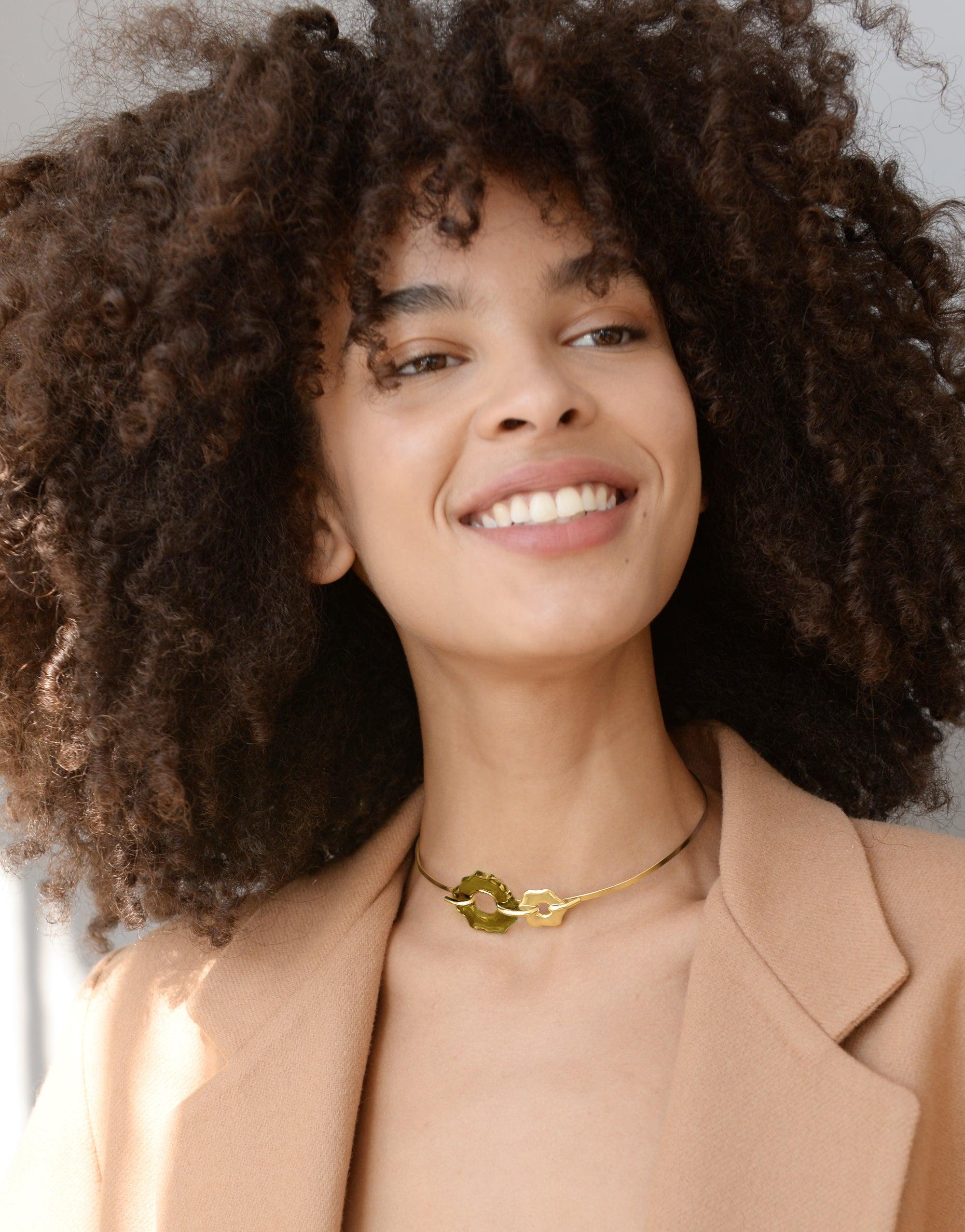 Woman with curly hair wearing Avens Choker Necklace, featuring eco-friendly glass pendant inspired by Arctic flowers. Elegant design suitable for day to evening wear, handcrafted in Los Angeles. Avens Choker Necklace by CLED