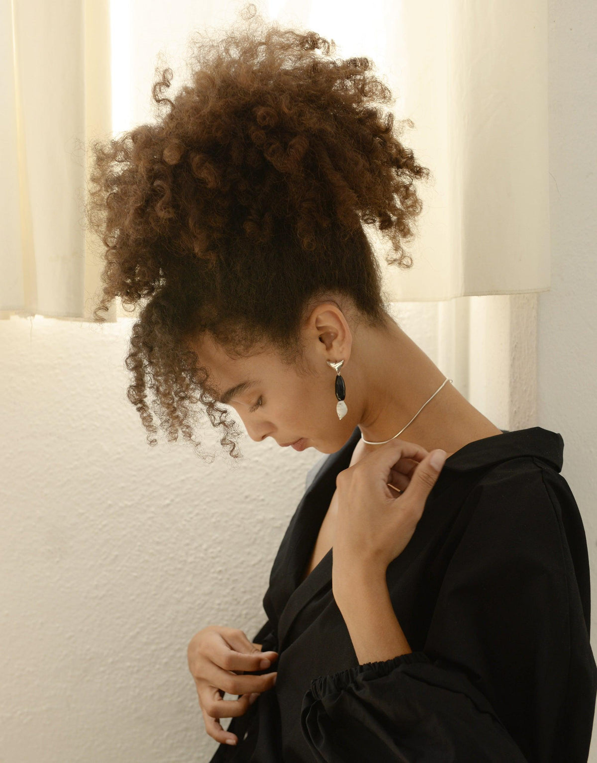 Elegant model wearing Orca Earrings from Floating Glacier Collection, showcasing eco-friendly design with repurposed glass. Sustainable jewelry highlighting climate change awareness. Handmade in Los Angeles. Orca Earrings by CLED.