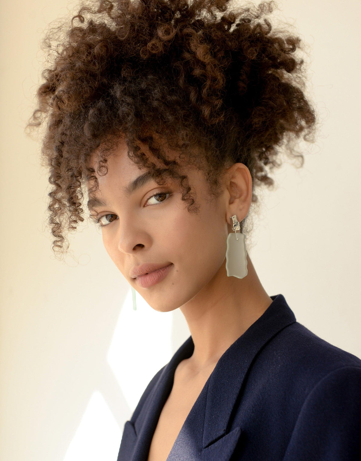 Elegant model showcasing Afloat Earrings, featuring hand-formed eco gem glass with a glacier-inspired design. Sustainable jewelry from the Floating Glacier Collection, reflecting climate change awareness. Handcrafted in Los Angeles. CLED, Afloat Earrings.