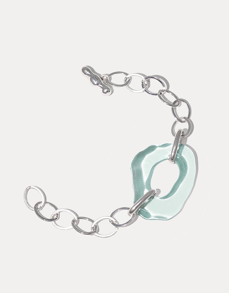 Sterling silver oval chain bracelet with organic free-shaped eco gem pendant in light blue, made from repurposed glass bottles. High Tide Oval Chain Bracelet features a unique handcrafted design, showcasing sustainability and elegance. CLED