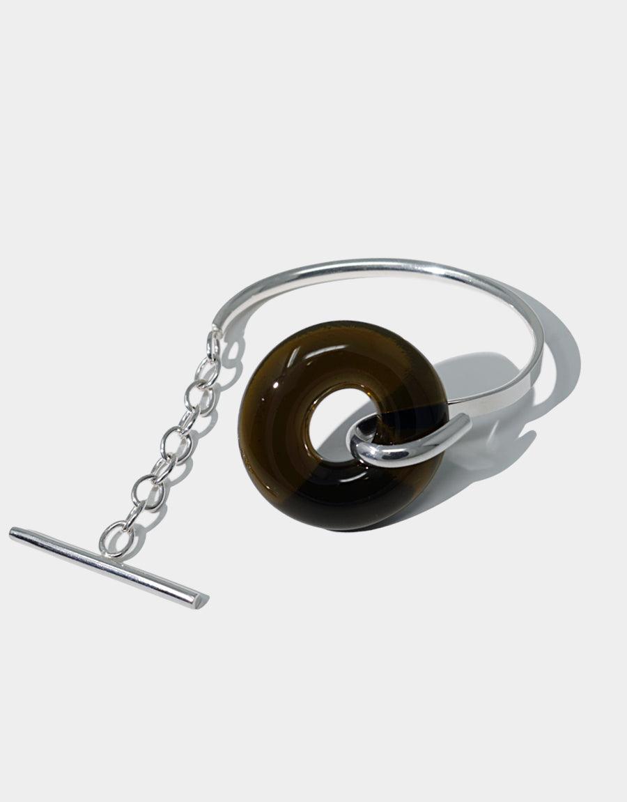 Elegant Opening Torus Toggle Bracelet featuring a dark brown glass ring on a sterling silver cuff with chain closure. Handcrafted sustainable jewelry piece with repurposed glass. Classic and timeless design by CLED.